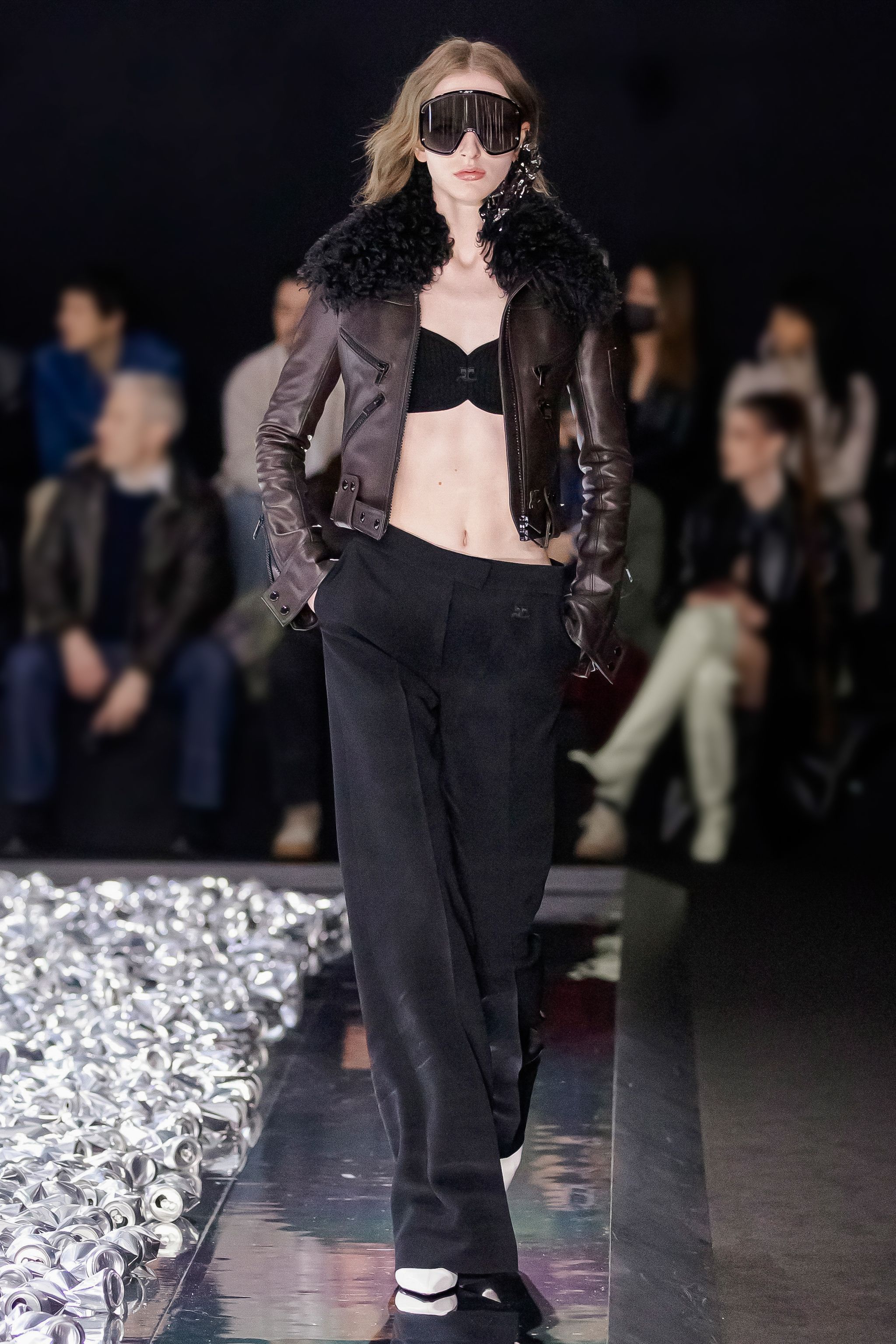 Elegant runway model in Courrèges fashion with black leather jacket and stylish accessories.