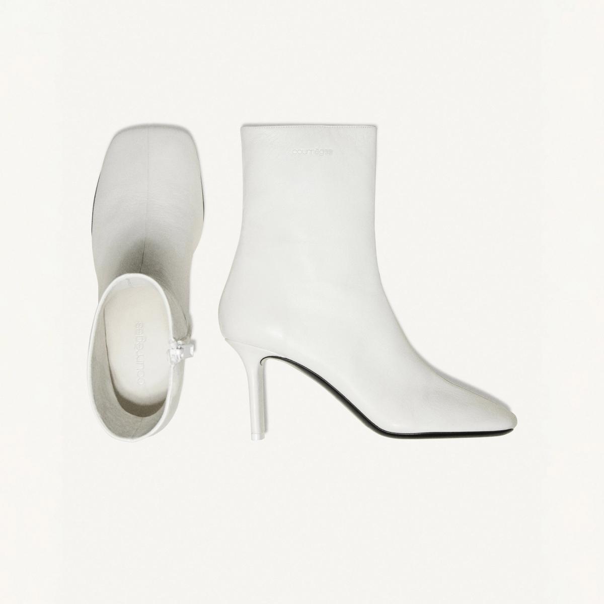 Elegant white high-heeled ankle boots by Courrèges for contemporary fashion style.