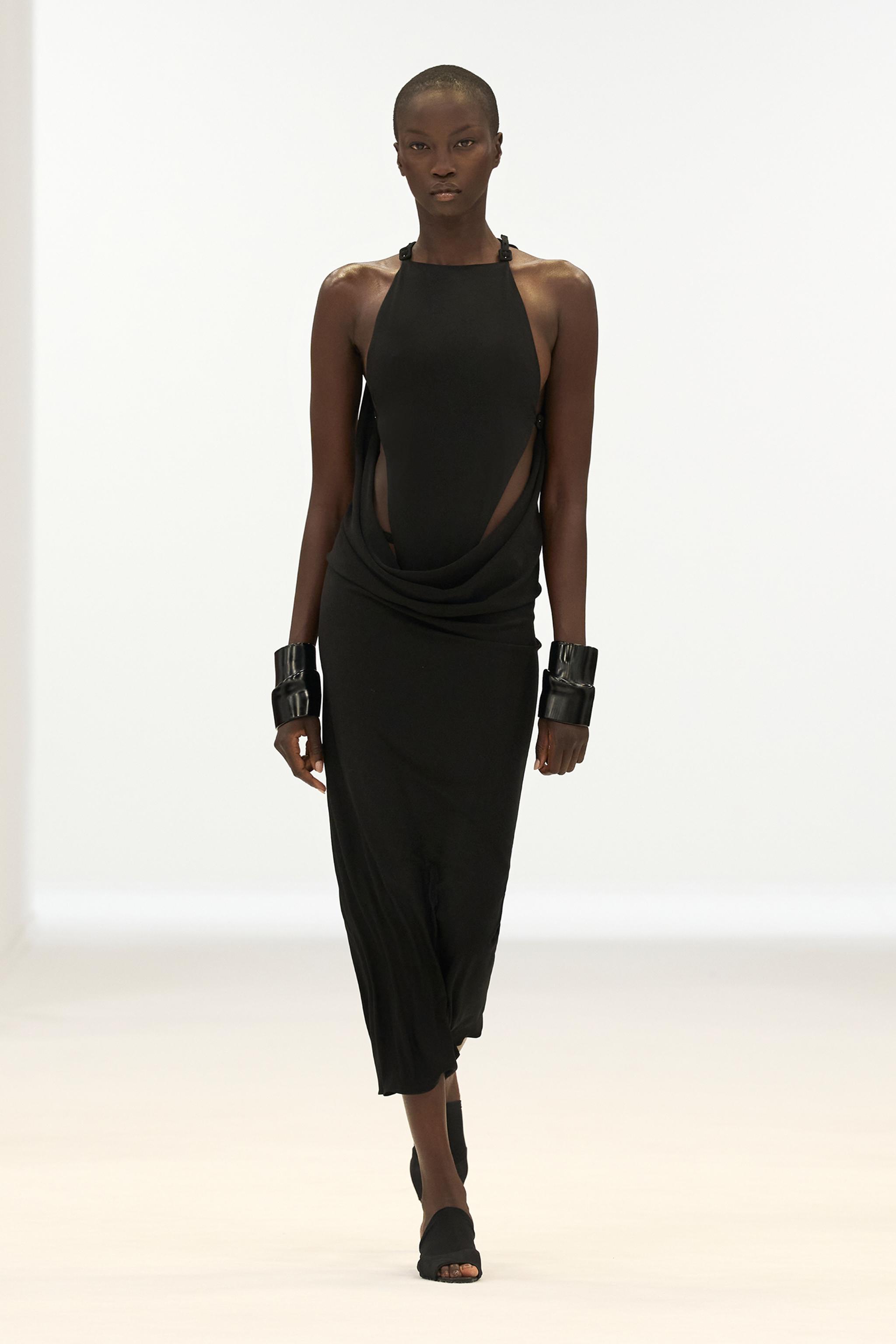 Elegant black designer dress showcased on a model for Courrèges fashion brand.