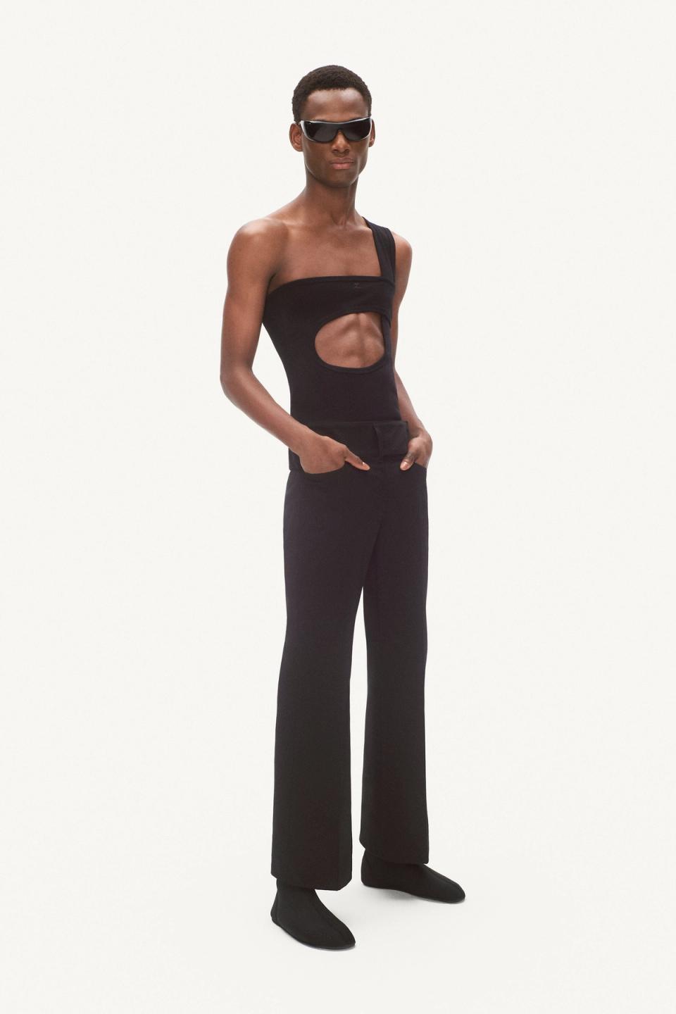 Elegant black Courrèges jumpsuit with cut-out details, paired with futuristic sunglasses.