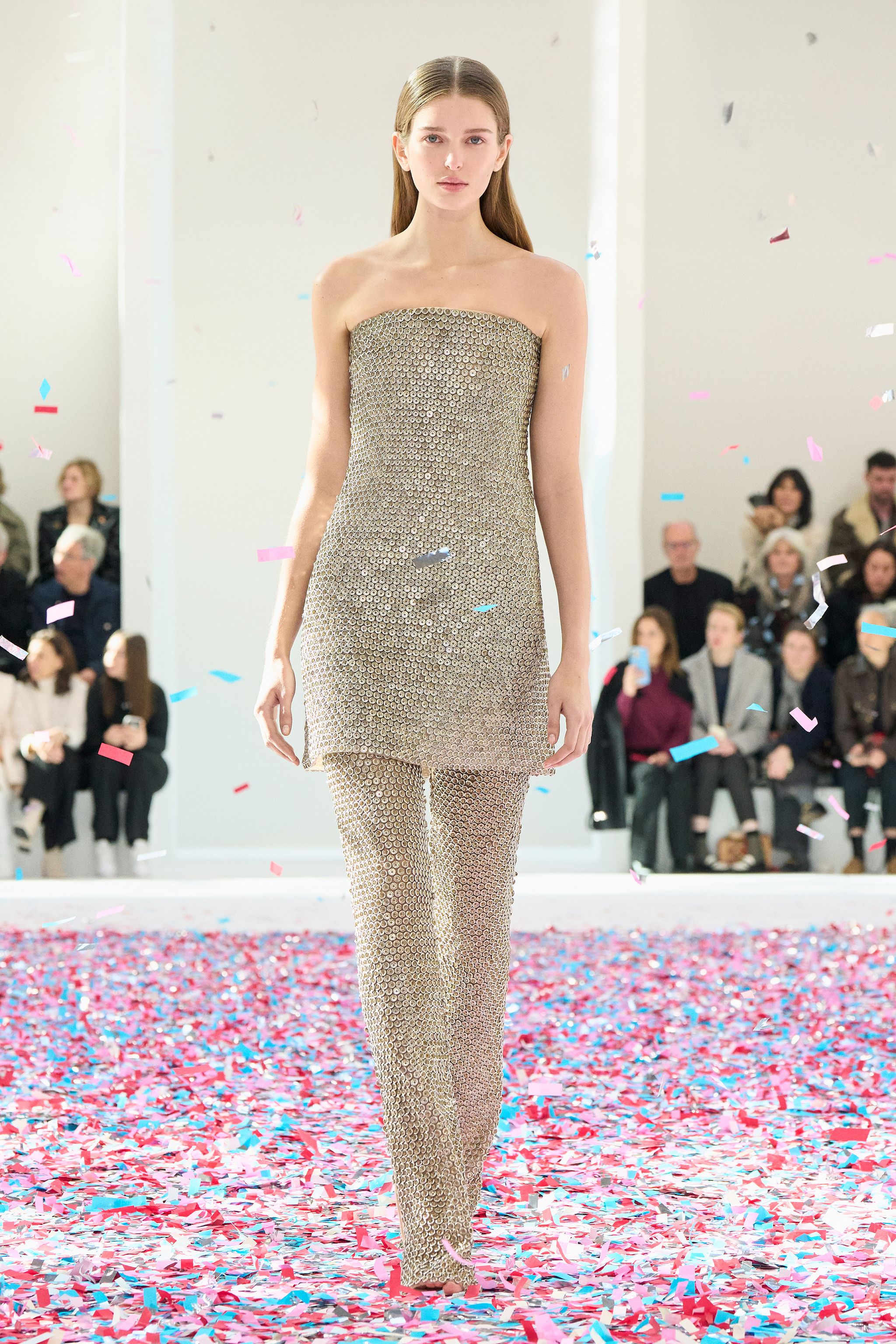 Elegant gold metallic strapless dress and matching trousers showcased on a runway for Courrèges.