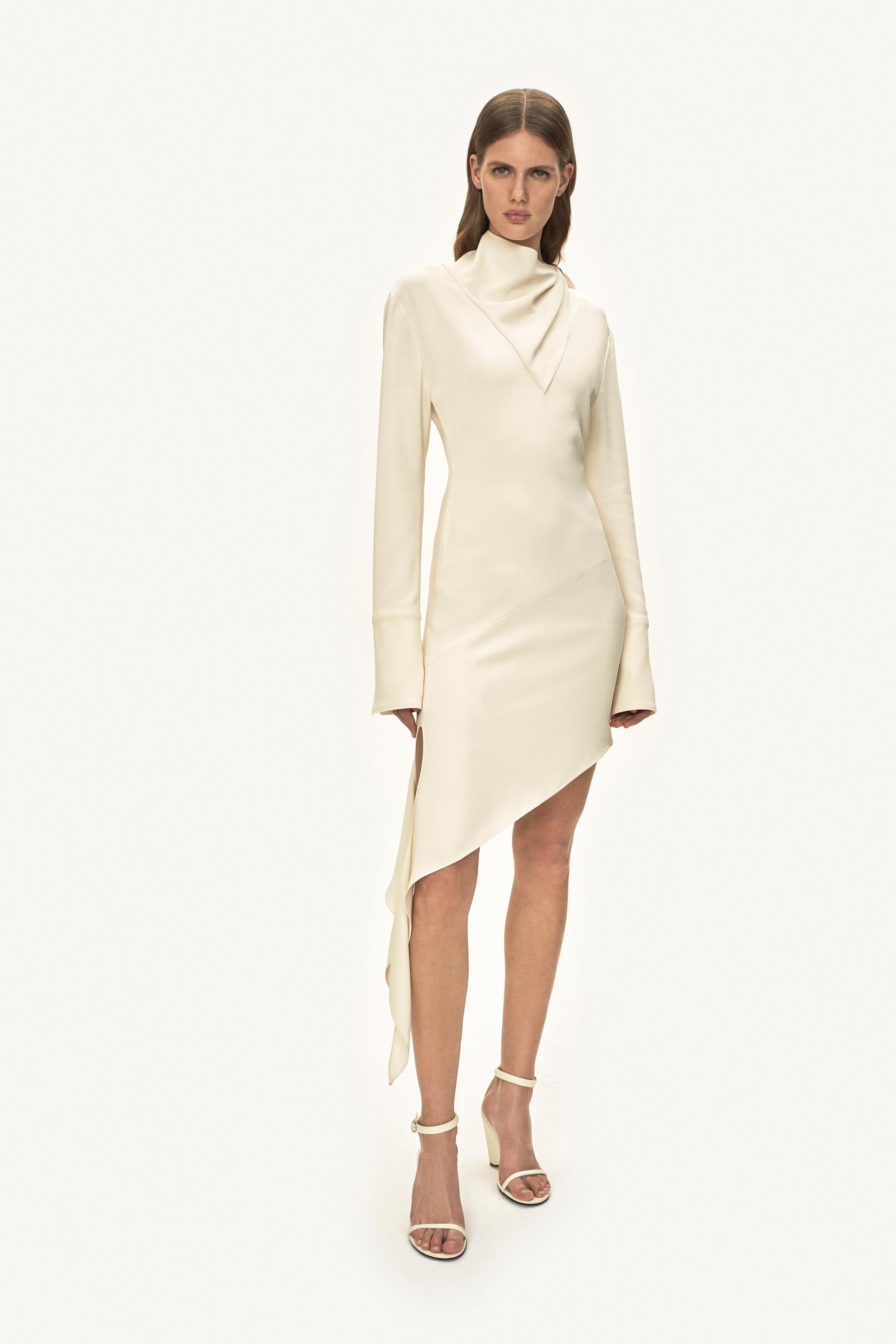 Robe crème élégante avec ourlet asymétrique et col haut, conçue pour la mode Courrèges.