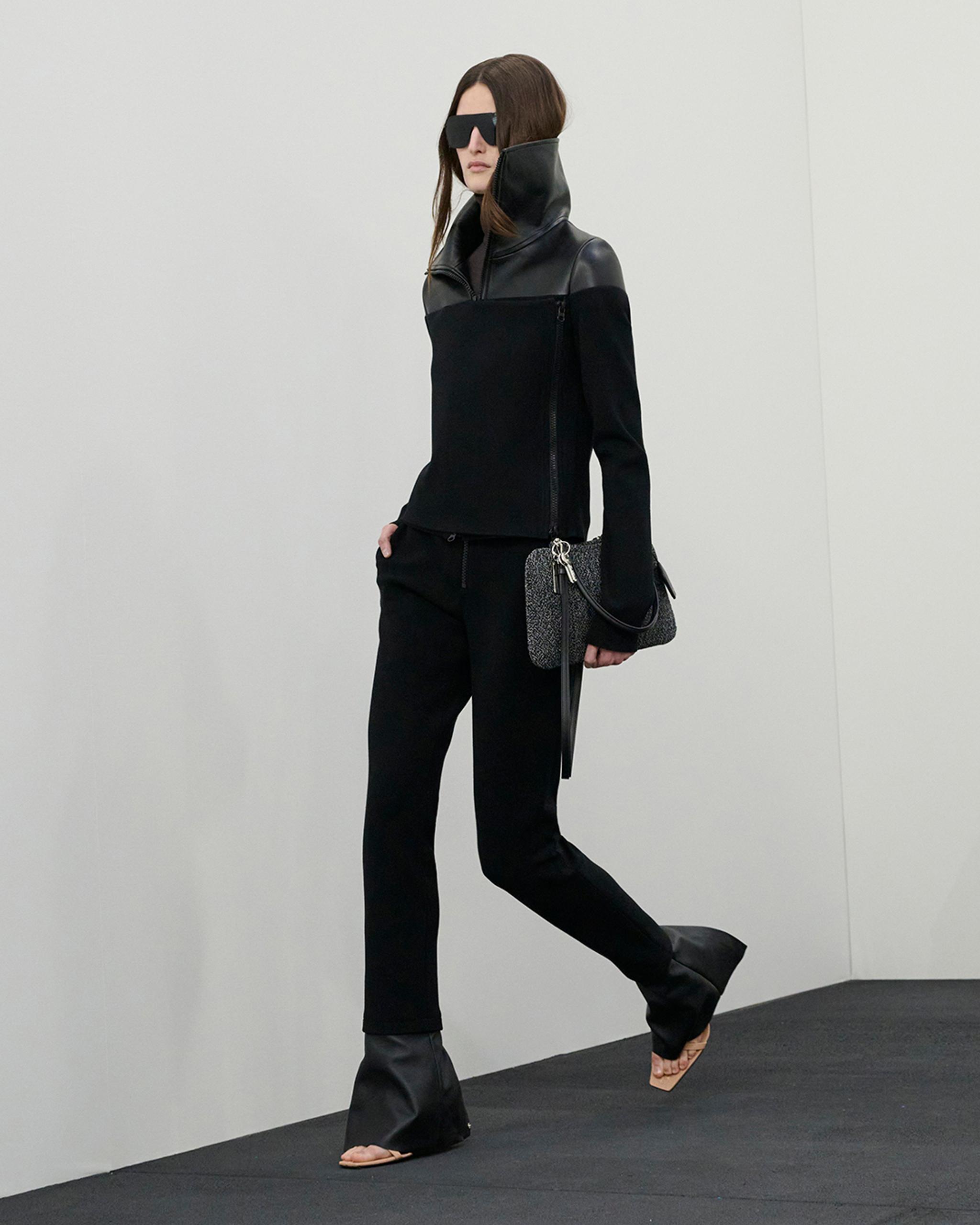 Elegant black outfit with leather details and oversized sunglasses, part of Courrèges' fashion collection.