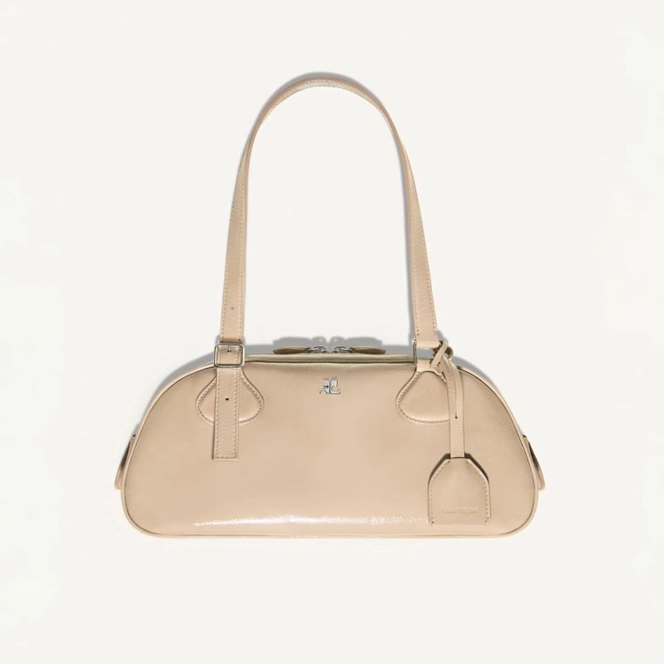 Elegant beige leather handbag from Courrèges featuring a structured design and silver accents.