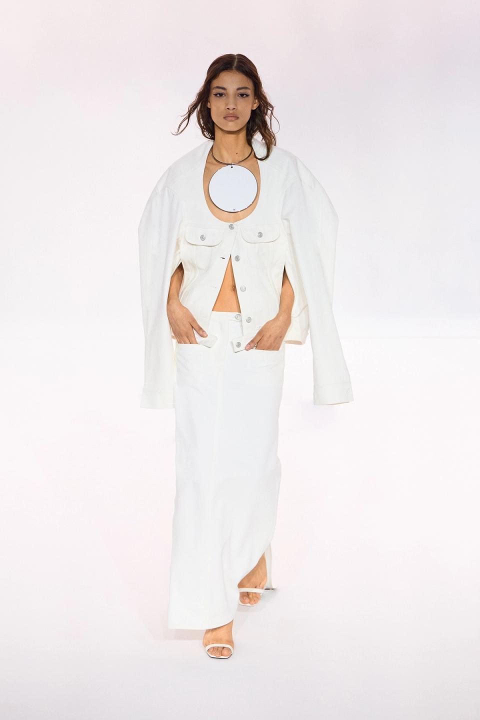 Elegant white fashion ensemble by Courrèges featuring a jacket, skirt, and modern accessories.