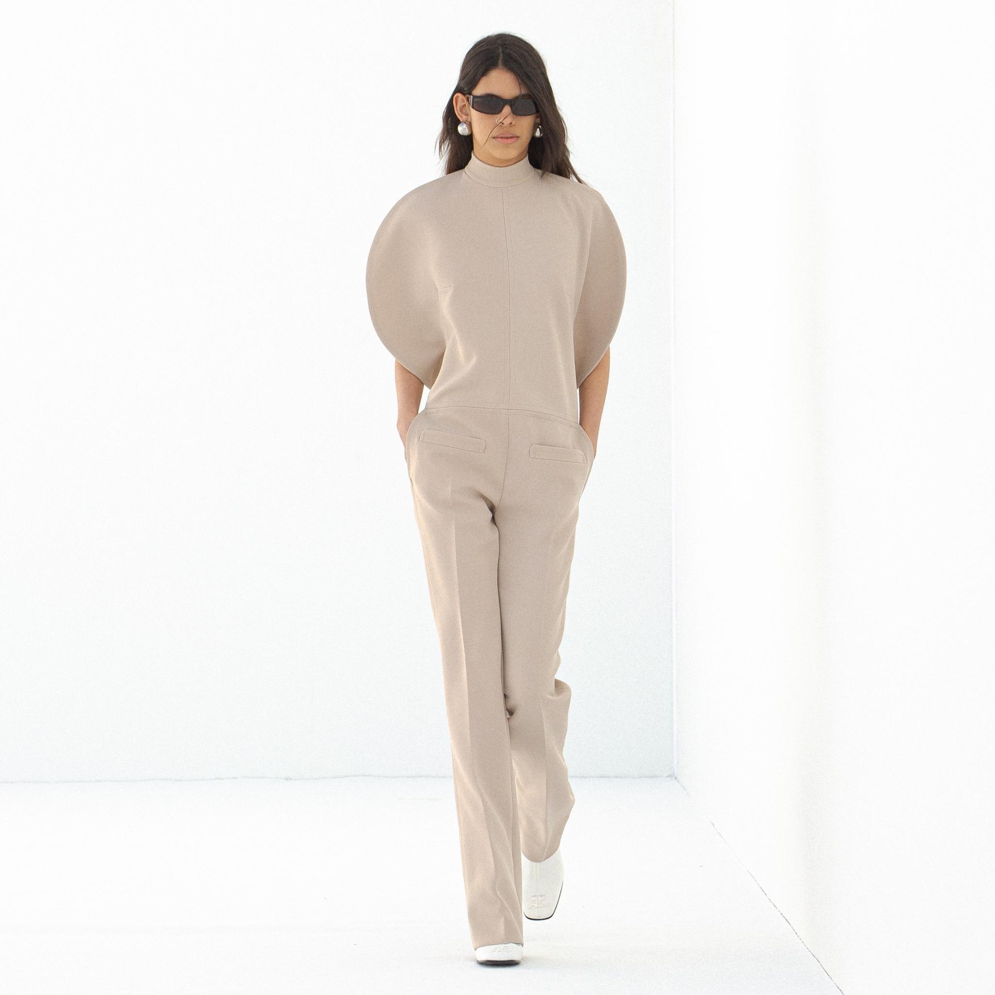 Tenue beige élégante avec des manches bouffantes, idéale pour la collection Courrèges sur un site e-commerce.