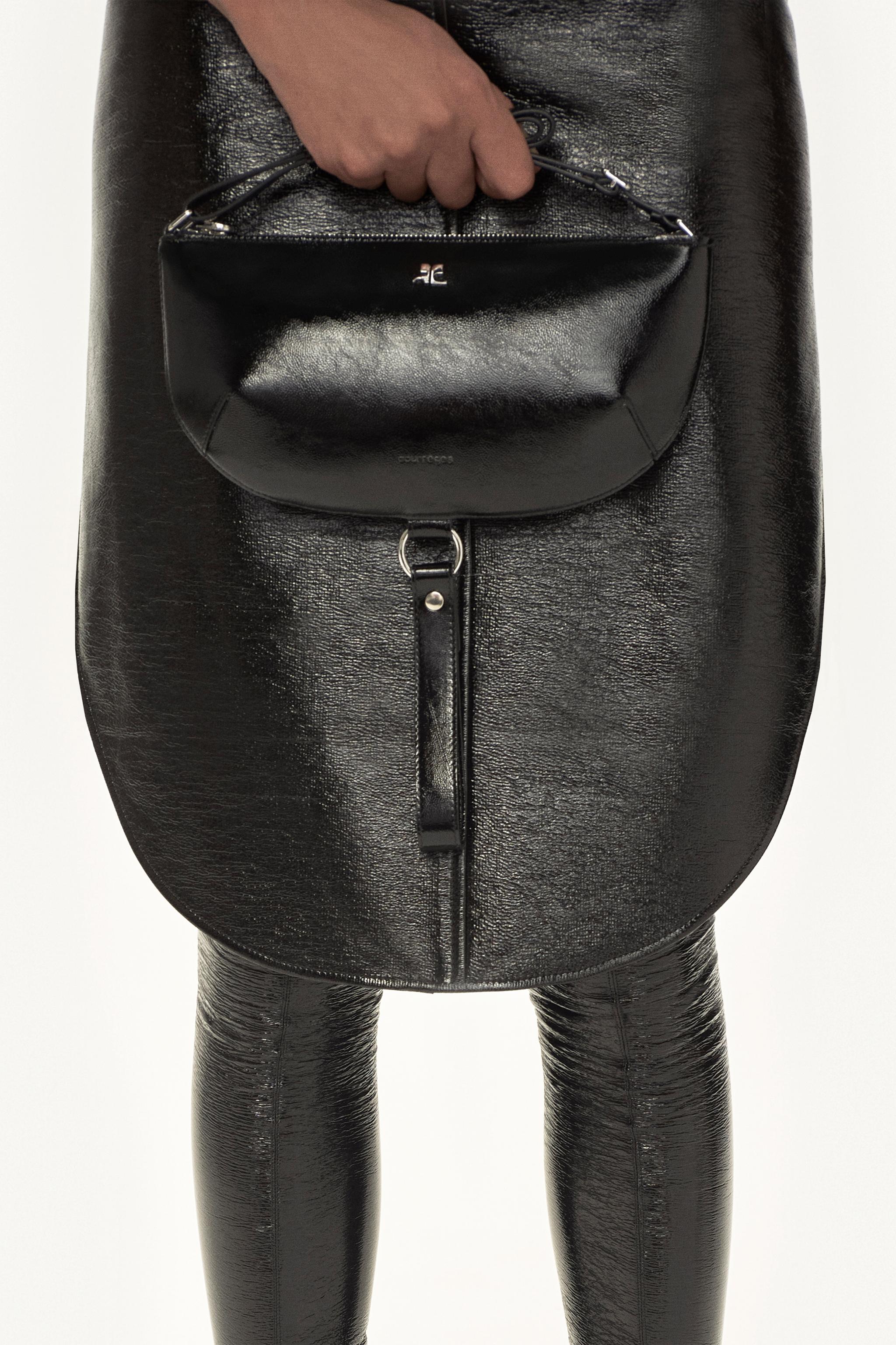Sac à main en cuir noir élégant avec détails métalliques, dans l’univers de la mode Courrèges.