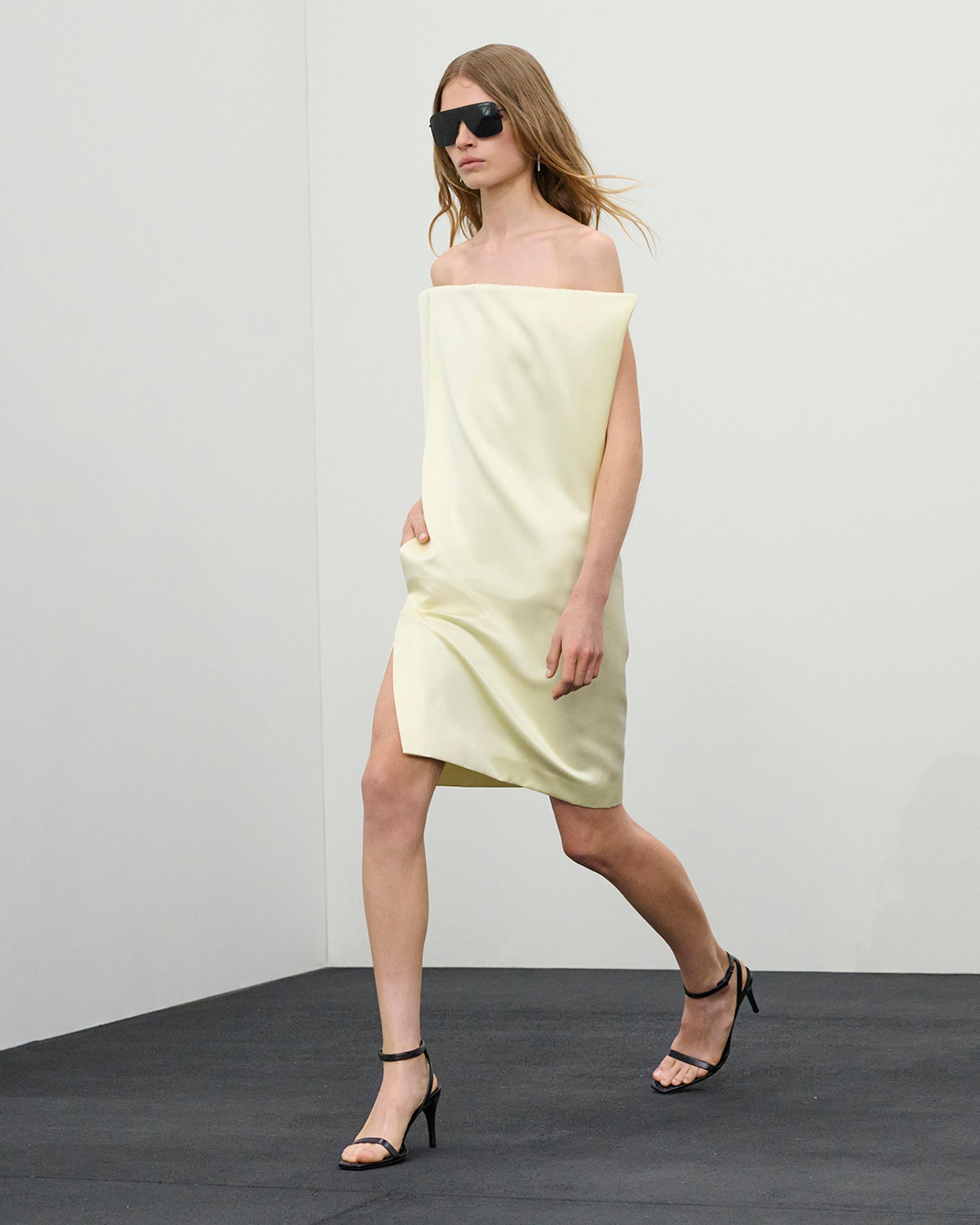 Elegant woman in off-shoulder silk dress, stylish sunglasses, perfect for Courrèges fashion.