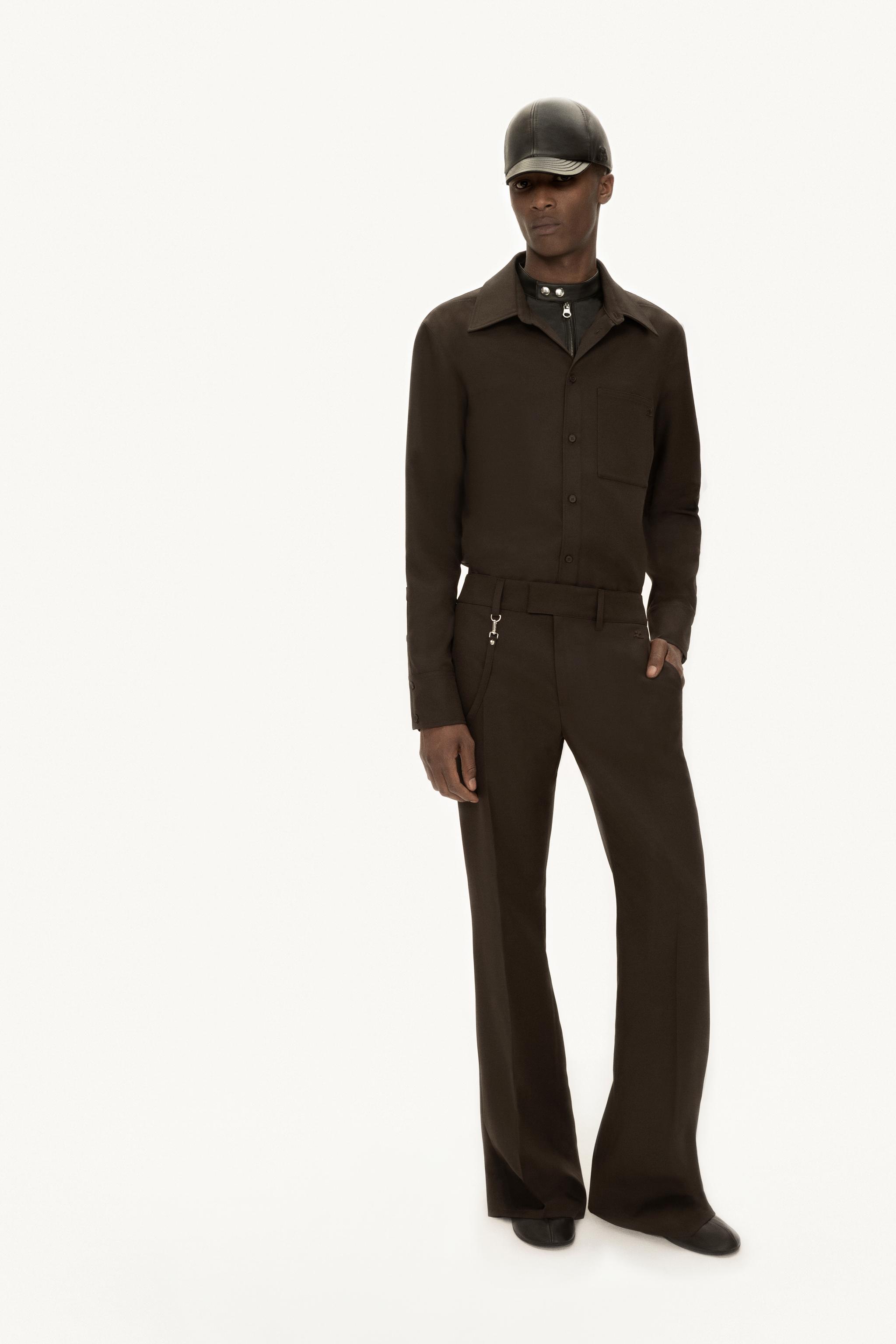 Tenue noire élégante avec pantalon ajusté et veste chic, mode Courrèges.