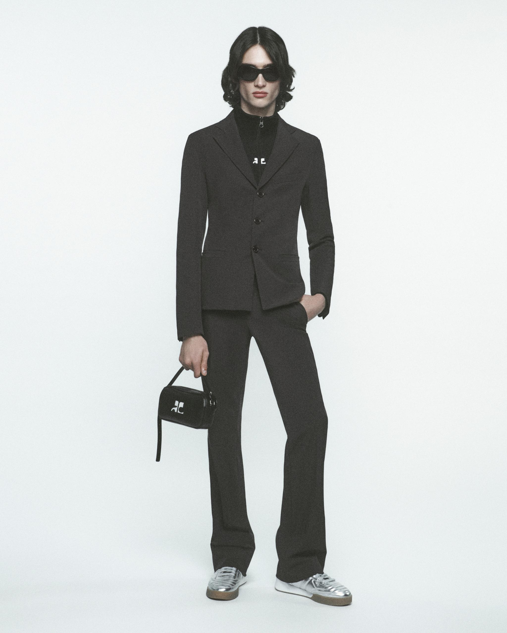 Elegant black tailored suit with sunglasses and sneakers for Courrèges fashion style.