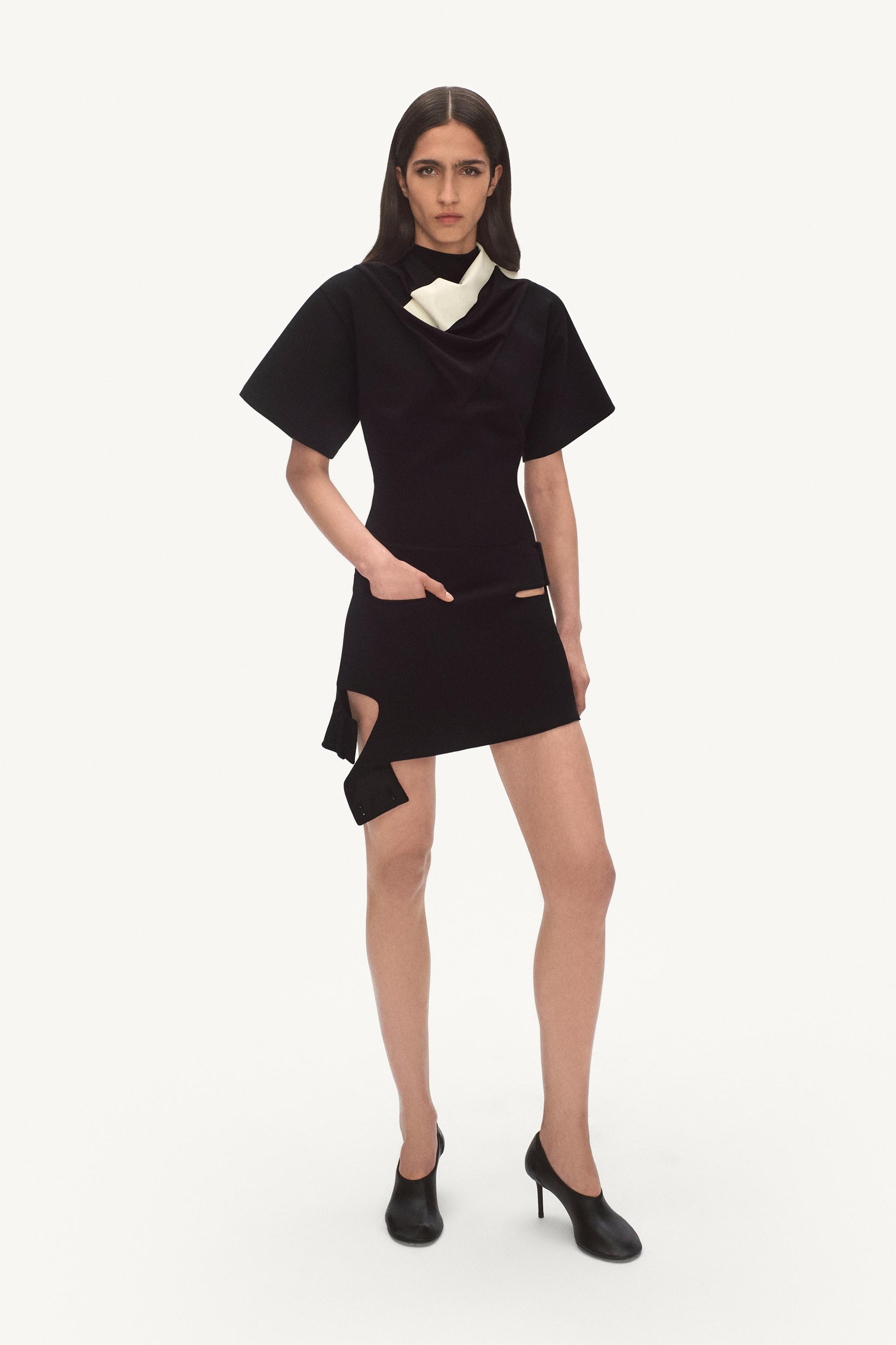 Elegant black dress with cut-out details and asymmetric hem, showcasing Courrèges style.