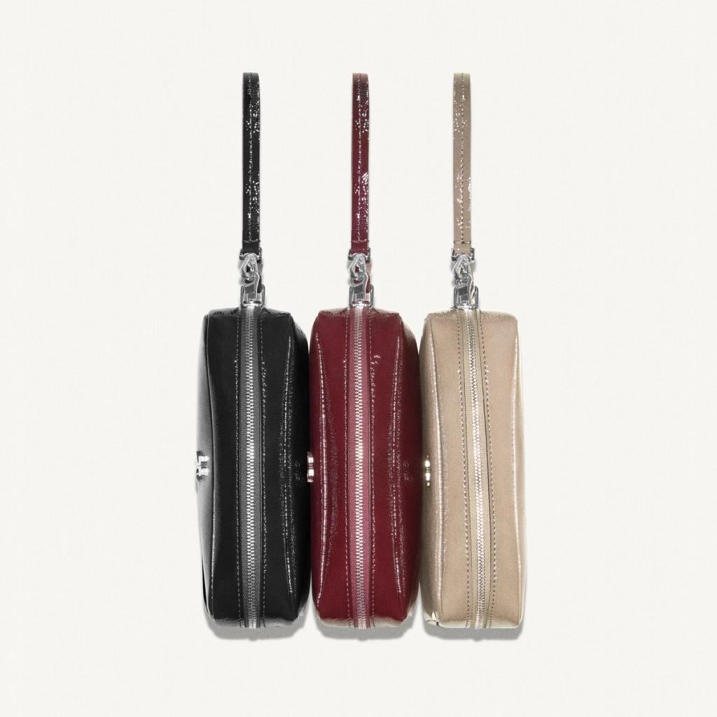 Sacs élégants noir, rouge et beige avec fermetures éclair brillantes, accessoires de mode Courrèges.