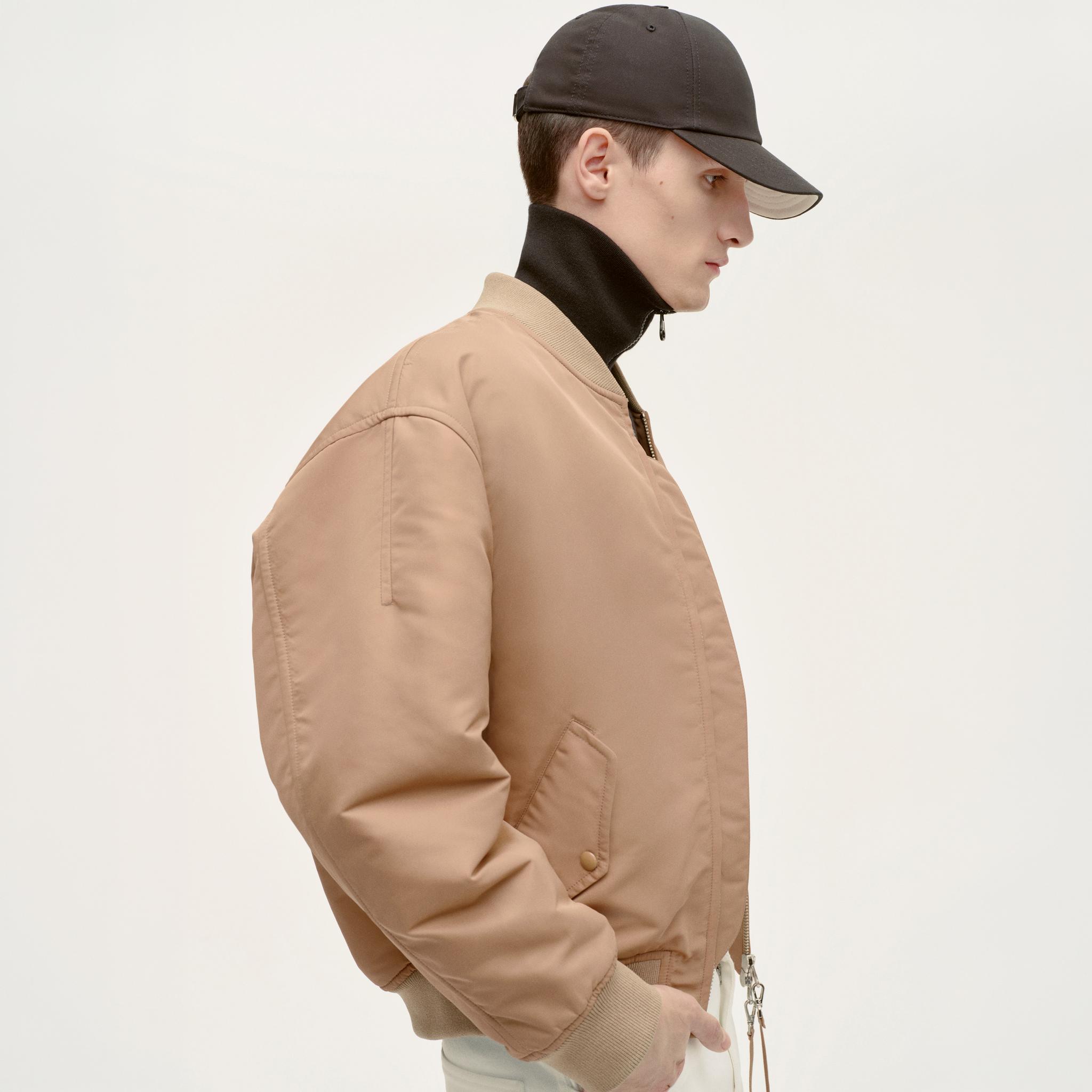Elegant beige bomber jacket by Courrèges with a modern, minimalist design for contemporary style.