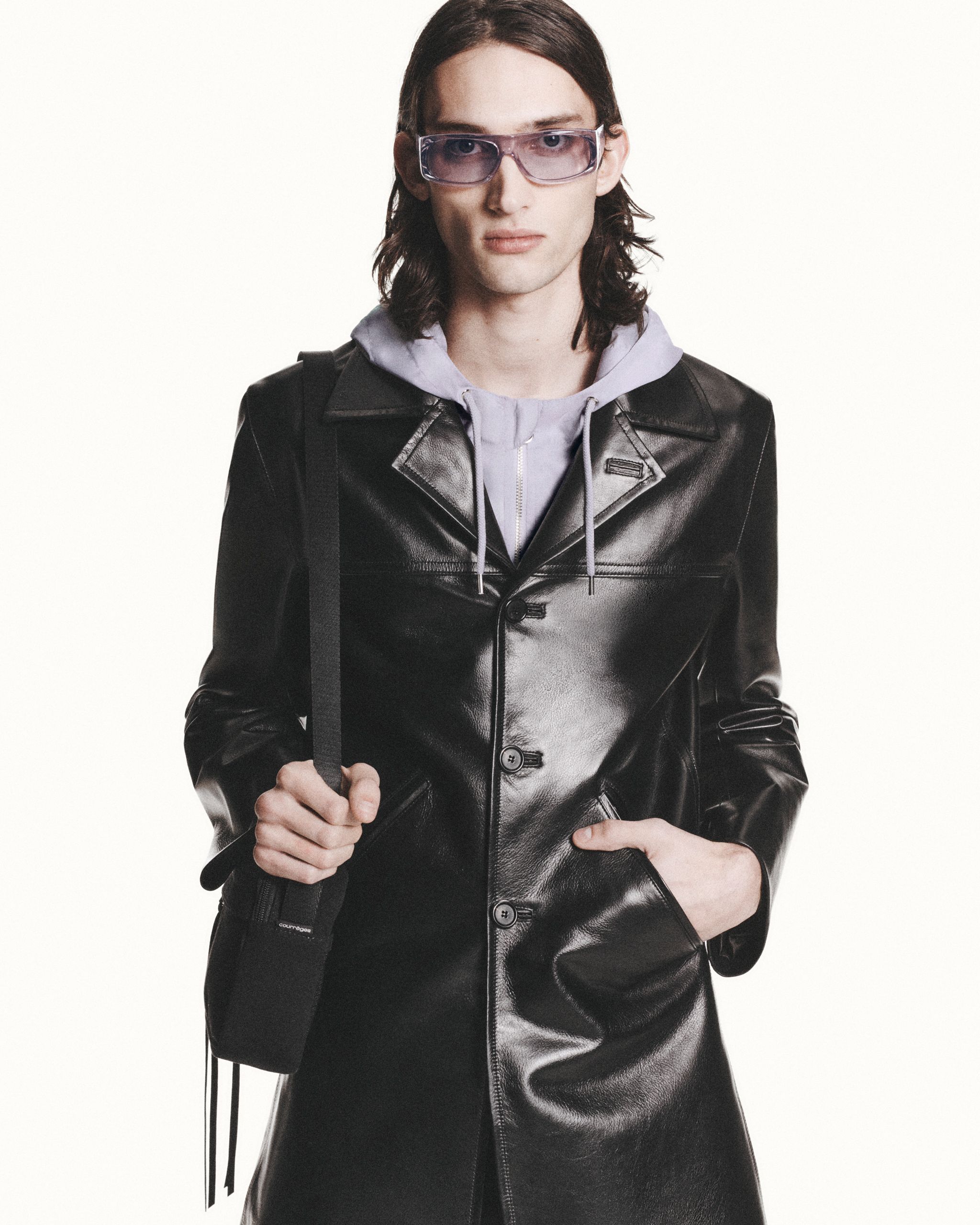 Elegant black leather jacket styled with a hoodie and fashionable accessories, Courrèges.
