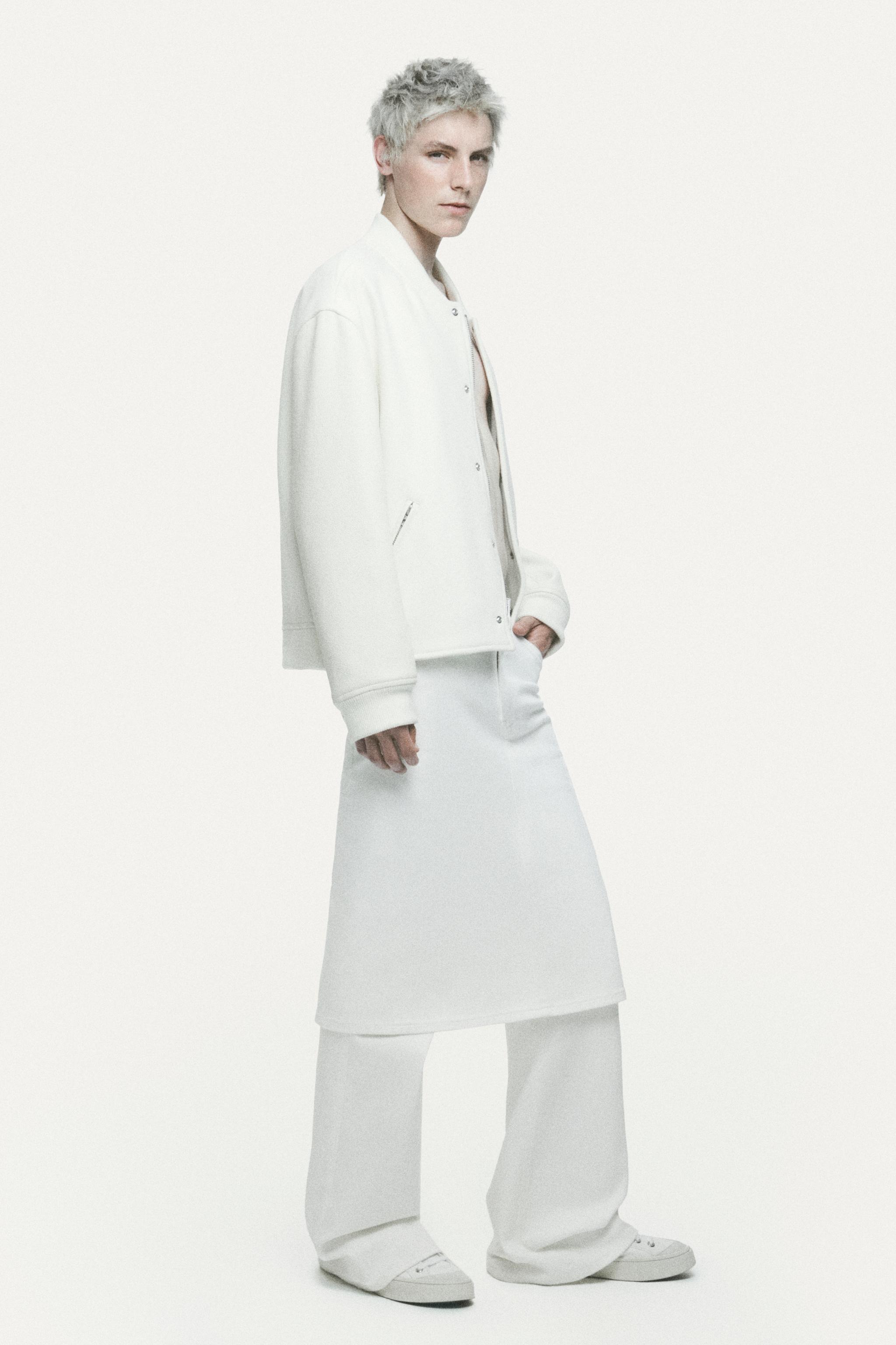 Elegant white casual outfit from Courrèges, featuring a jacket, skirt, and relaxed shoes.