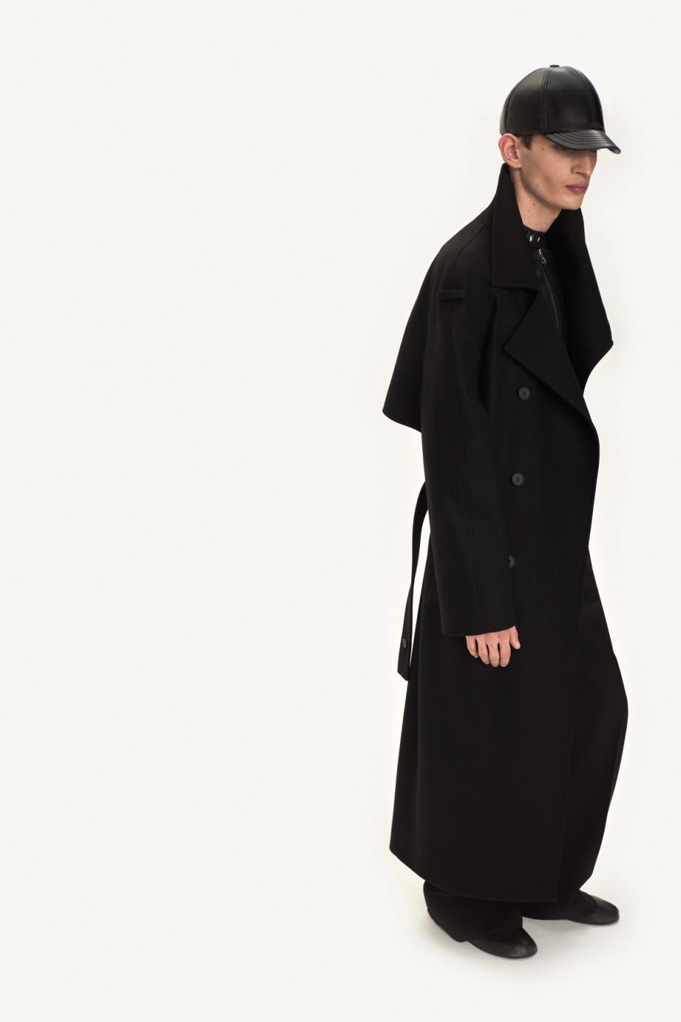 Elegant black trench coat with leather accessories, showcasing Courrèges' modern fashion style.