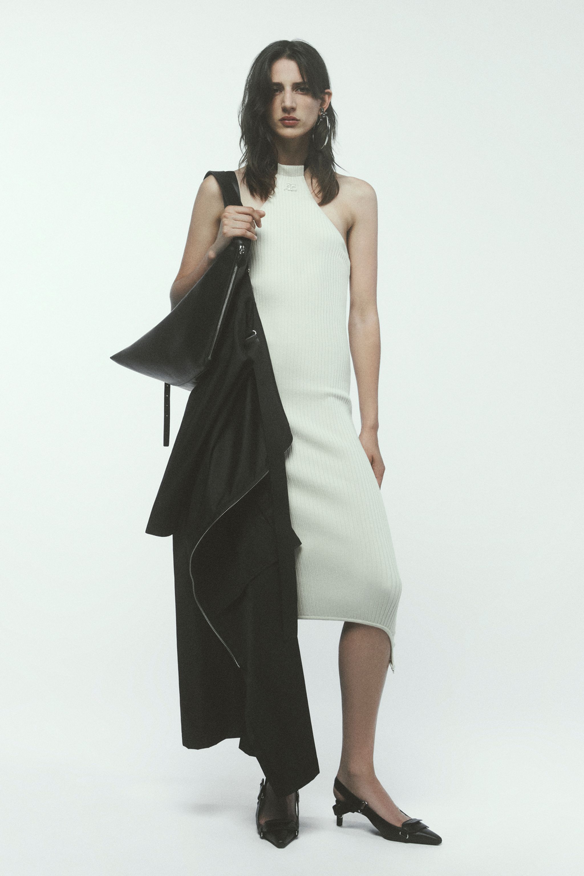 Elegant female model in white dress showcasing Courrèges fashion on an ecommerce site.
