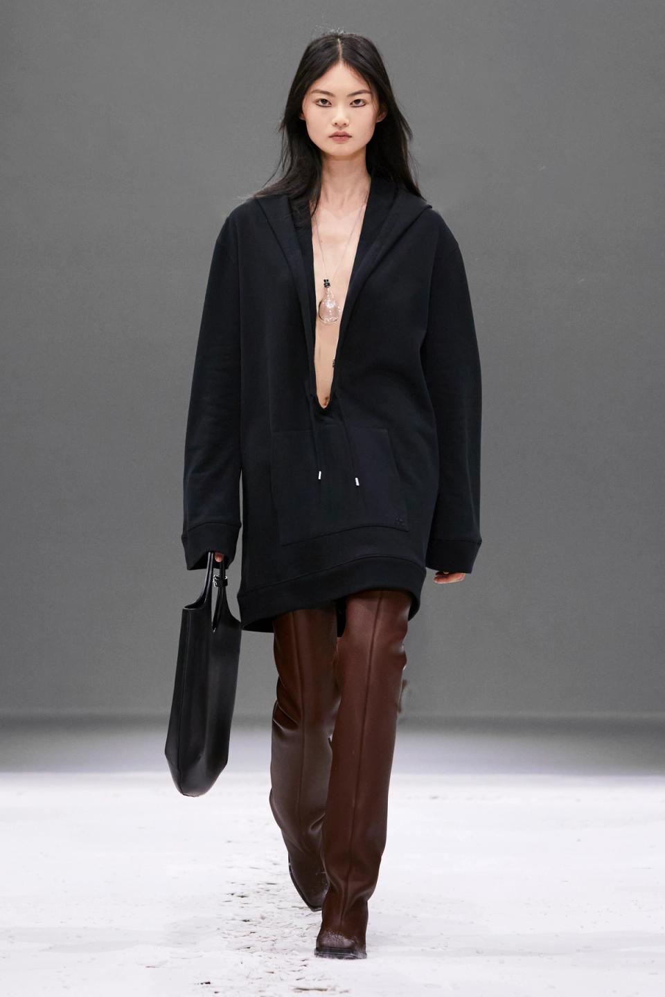 Elegant black oversized hoodie with a deep neckline, styled for Courrèges' modern fashion look.