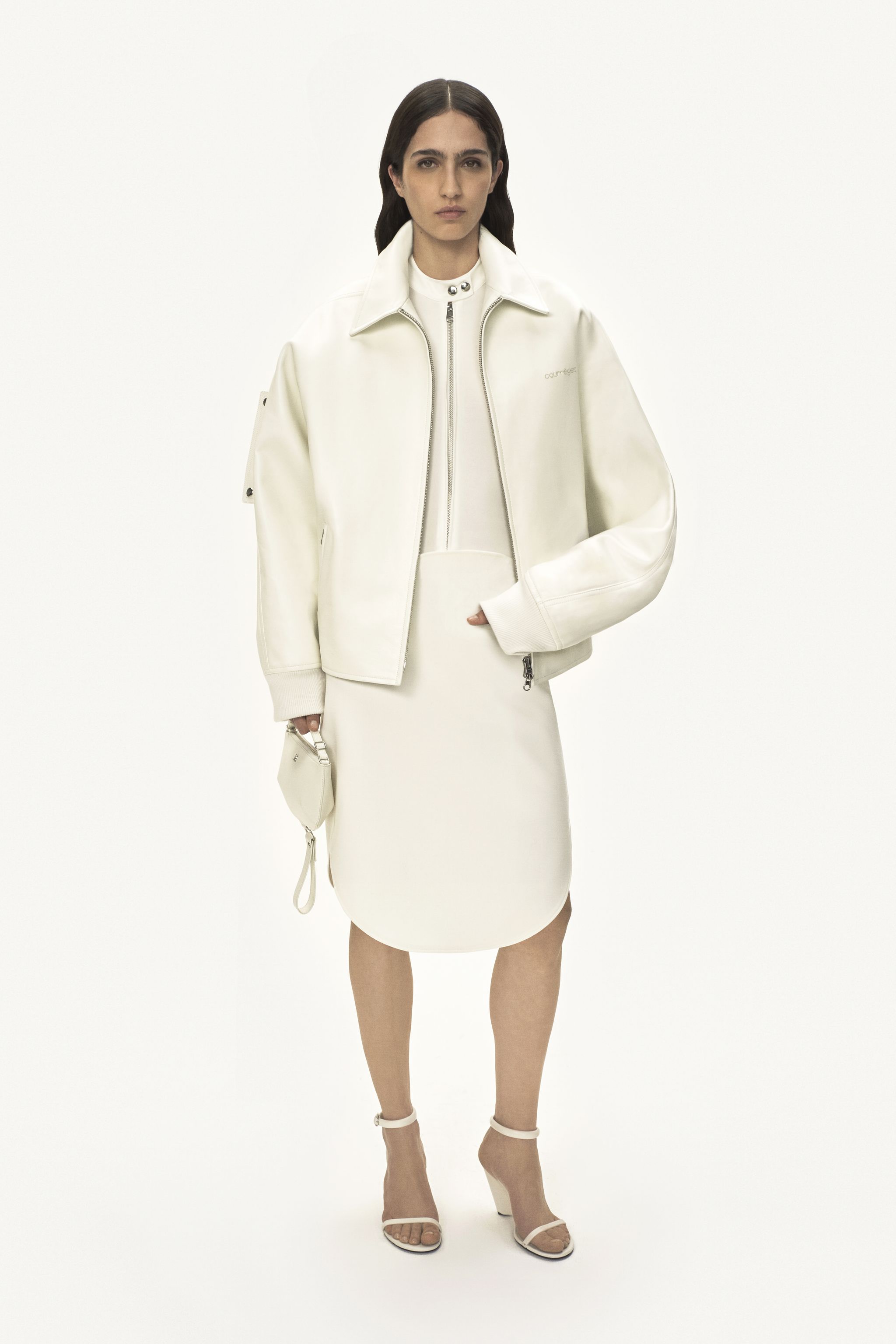 Elegant white Courrèges fashion look featuring a jacket, skirt, and heels for an ecommerce site.