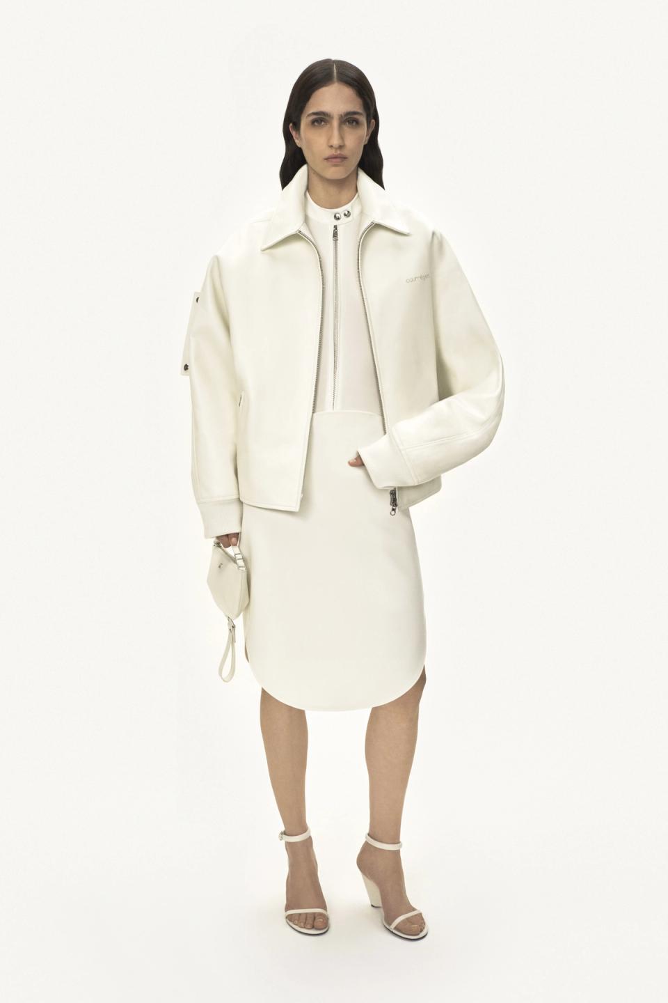 Elegant white Courrèges fashion look featuring a jacket, skirt, and heels for an ecommerce site.