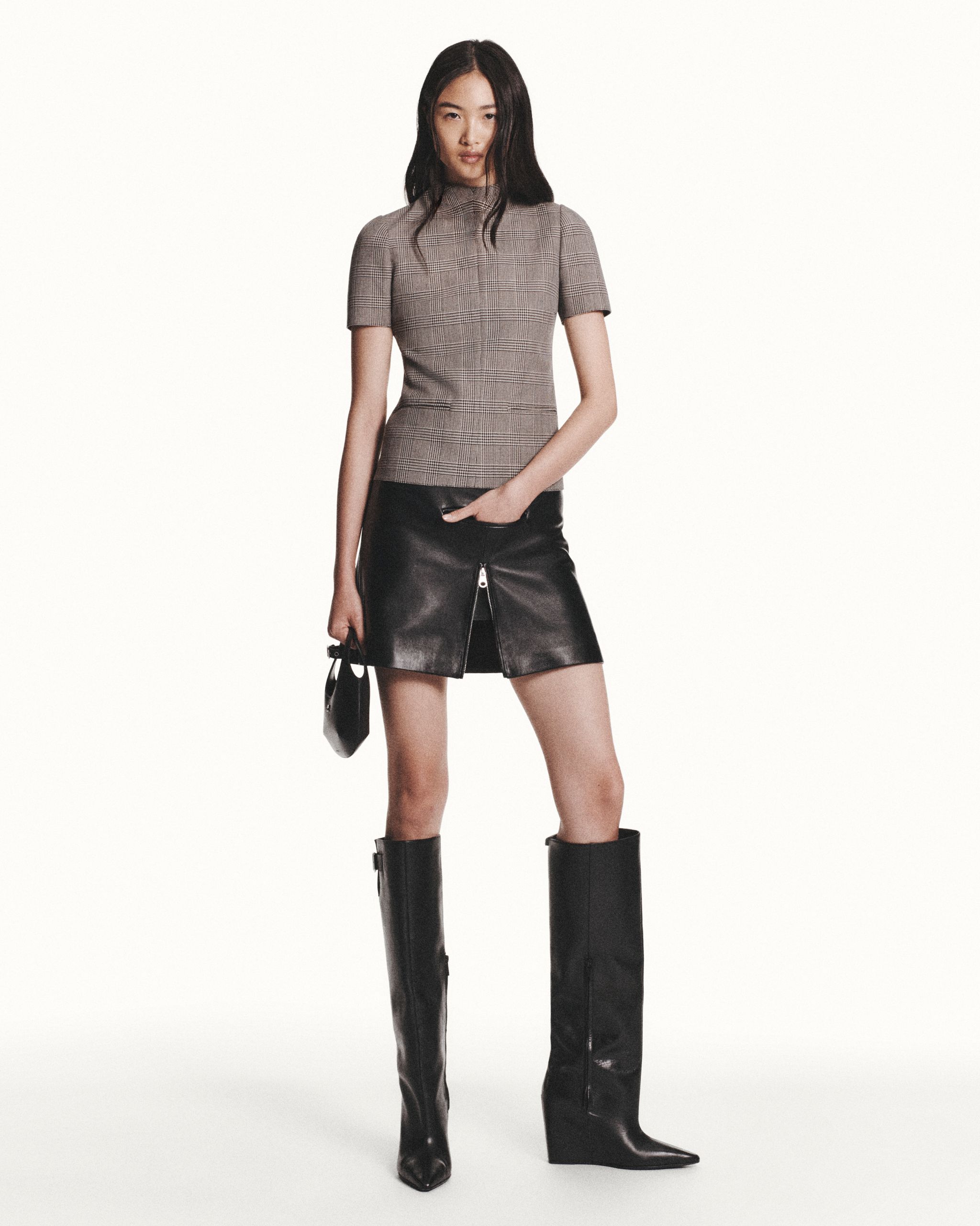 Elegant model in plaid top and leather skirt, showcasing Courrèges fashion for an e-commerce site.