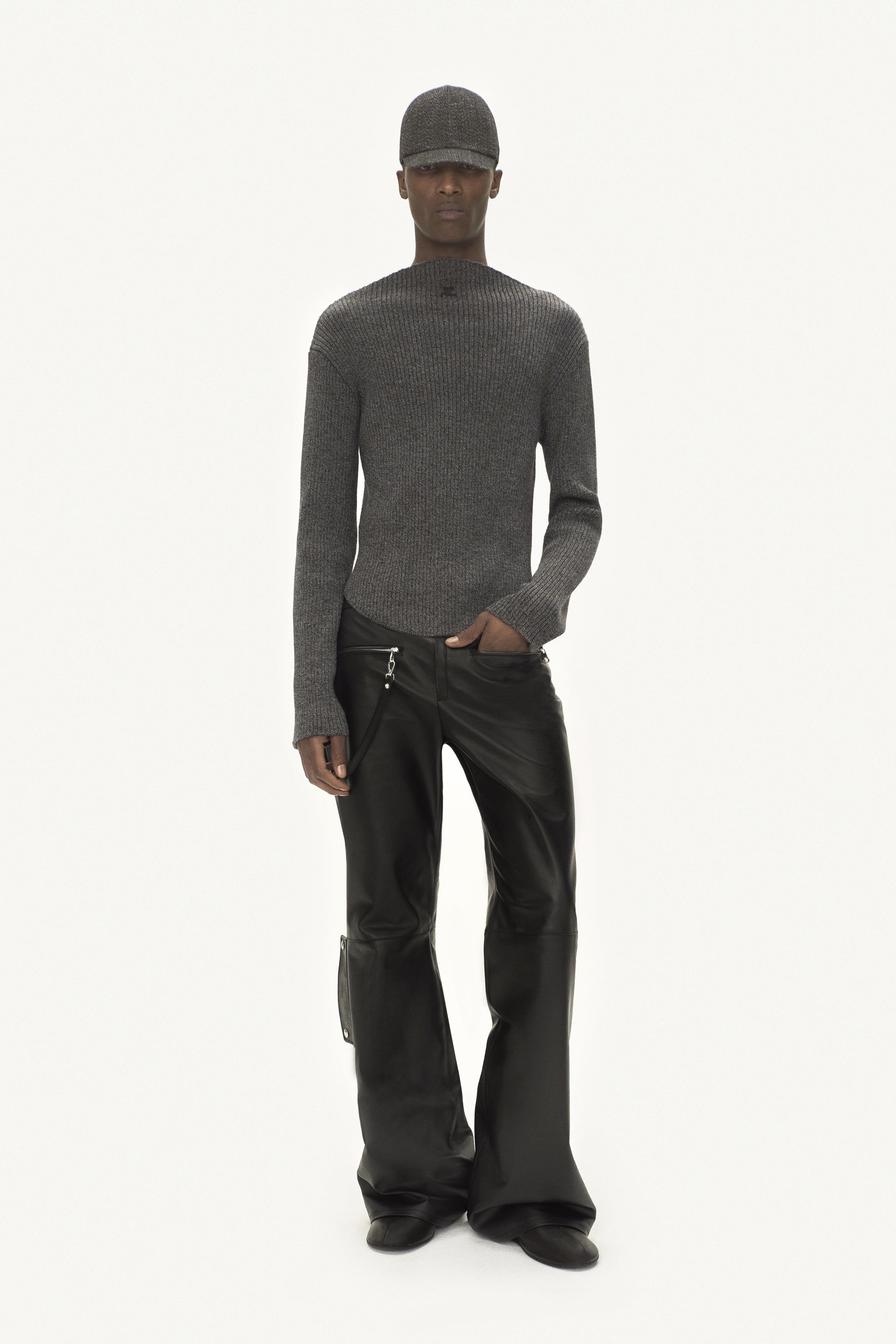 Elegant grey sweater and black leather pants for Courrèges fashion, on a model.