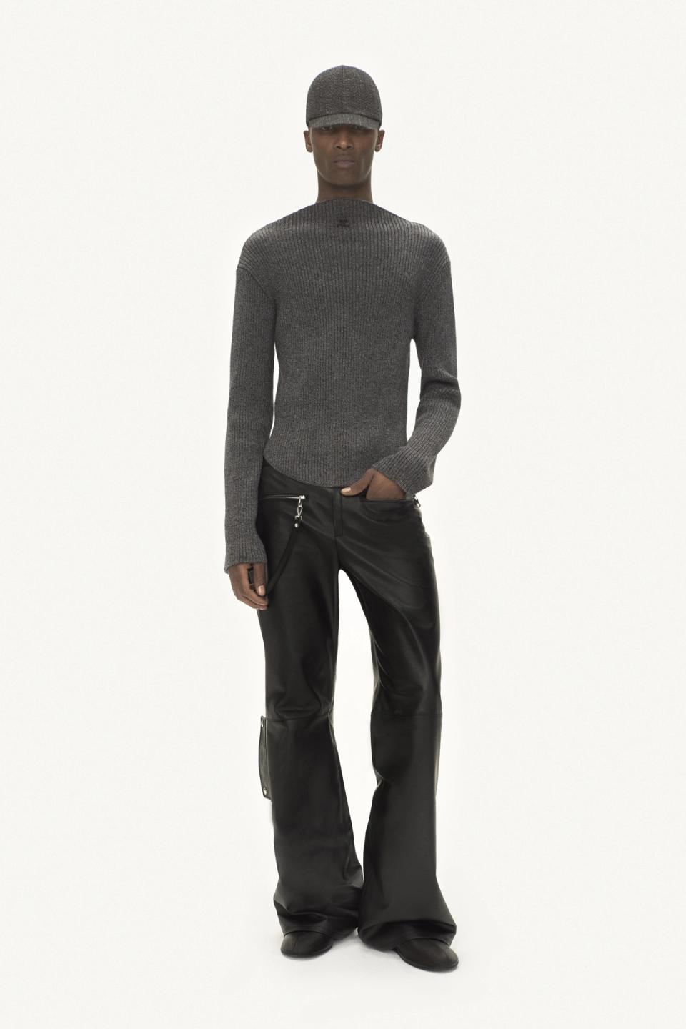 Elegant grey sweater and black leather pants for Courrèges fashion, on a model.