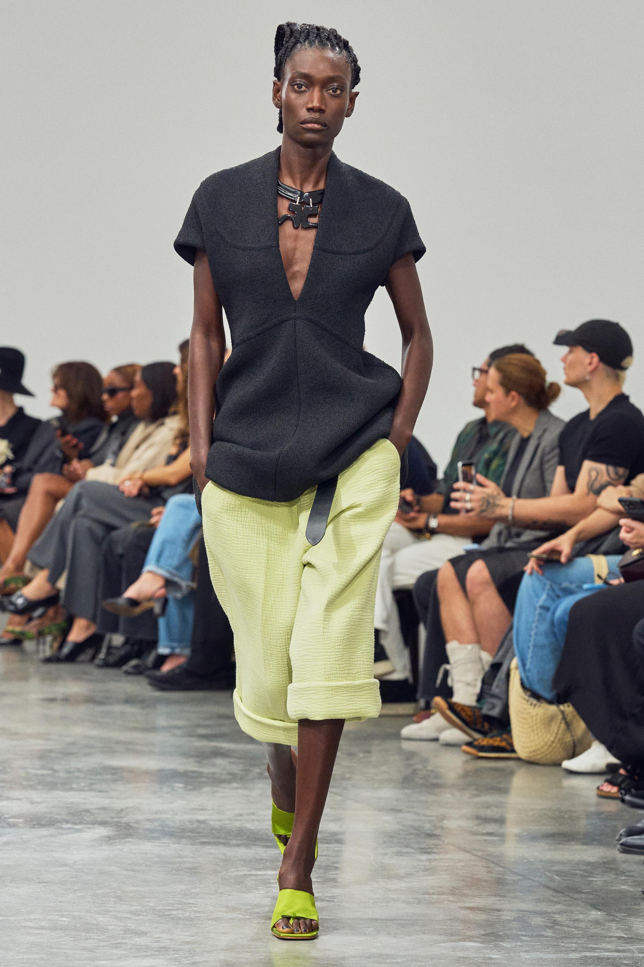 Elegant model wearing Courrèges fashion on runway at a chic show for an ecommerce site.