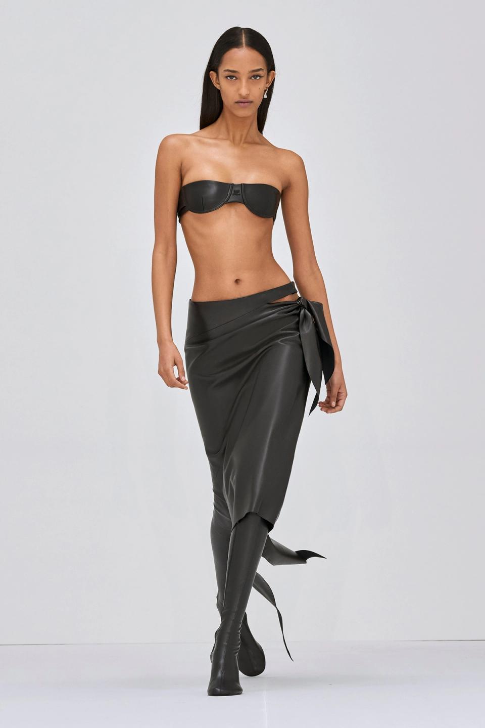 Elegant black leather bustier and asymmetric skirt with tied detail from Courrèges.