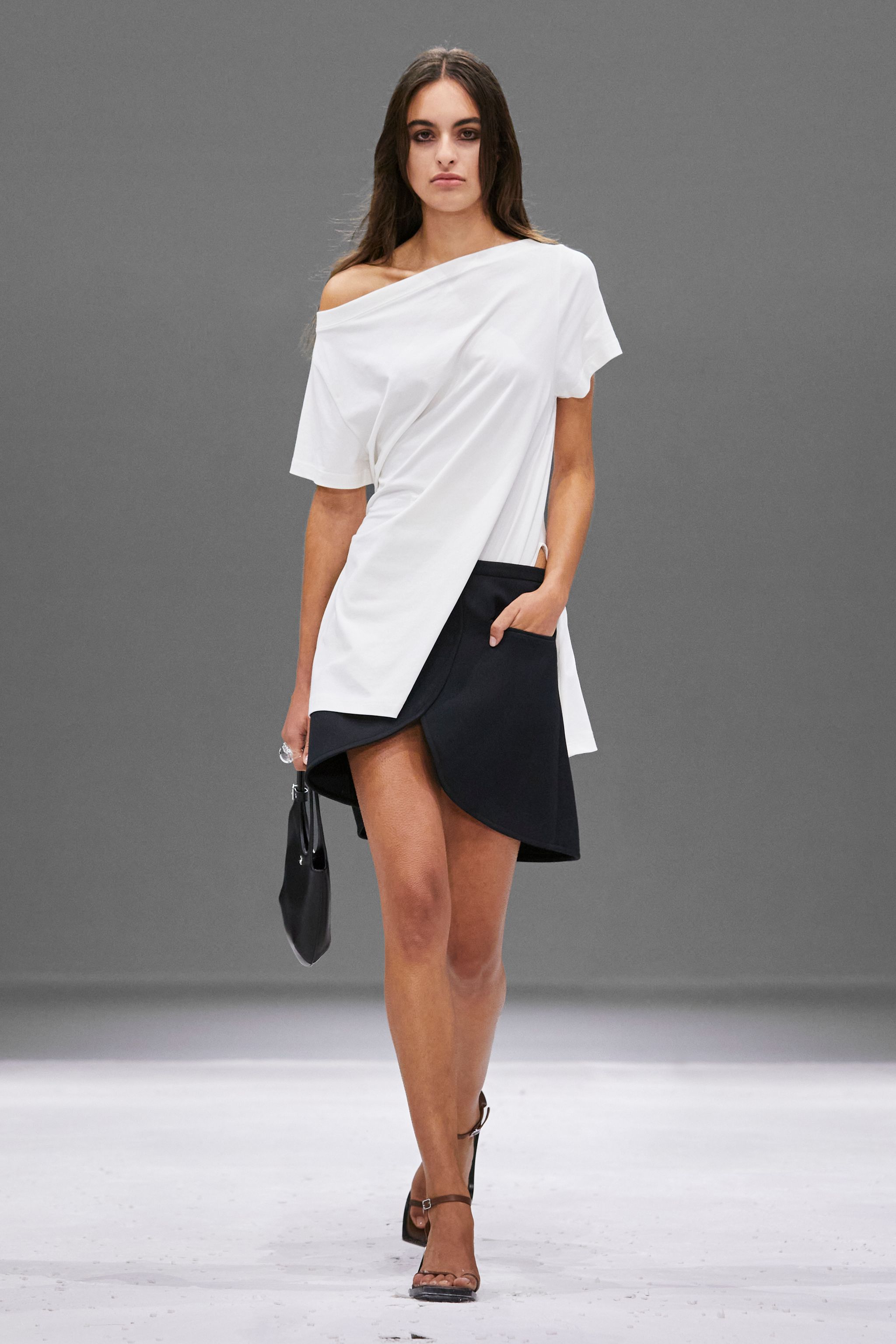 Elegant model in white and black Courrèges fashion for modern, chic style on an ecommerce site.