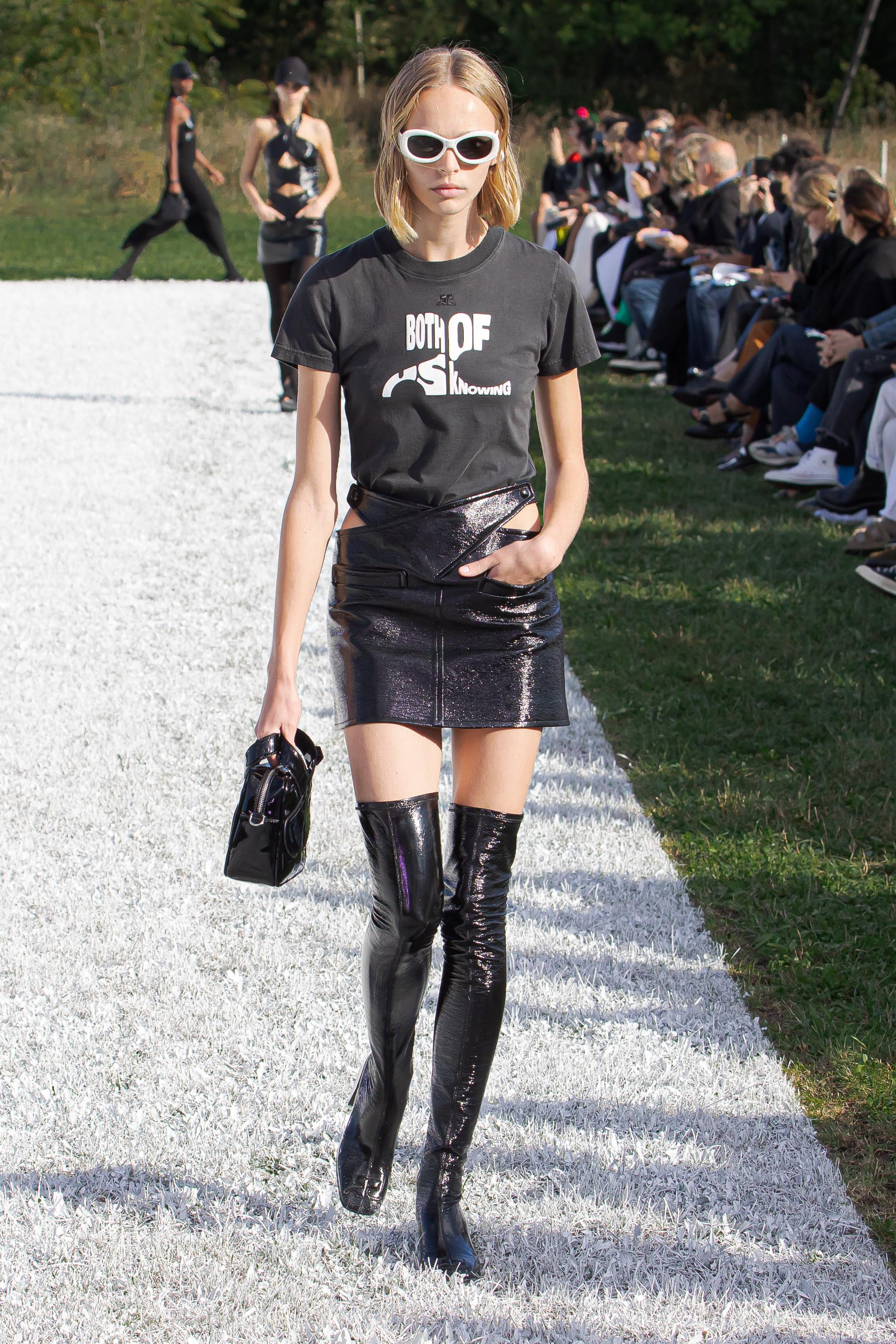 Model walking on runway wearing Courrèges edgy black fashion outfit with accessories.