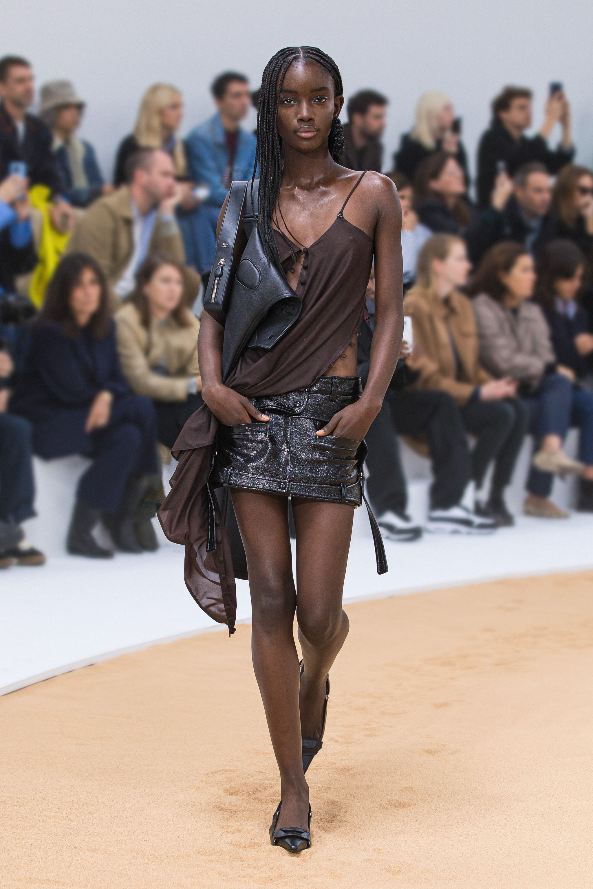 Elegant model wearing Courrèges fashion on runway, showcasing stylish clothing for ecommerce.