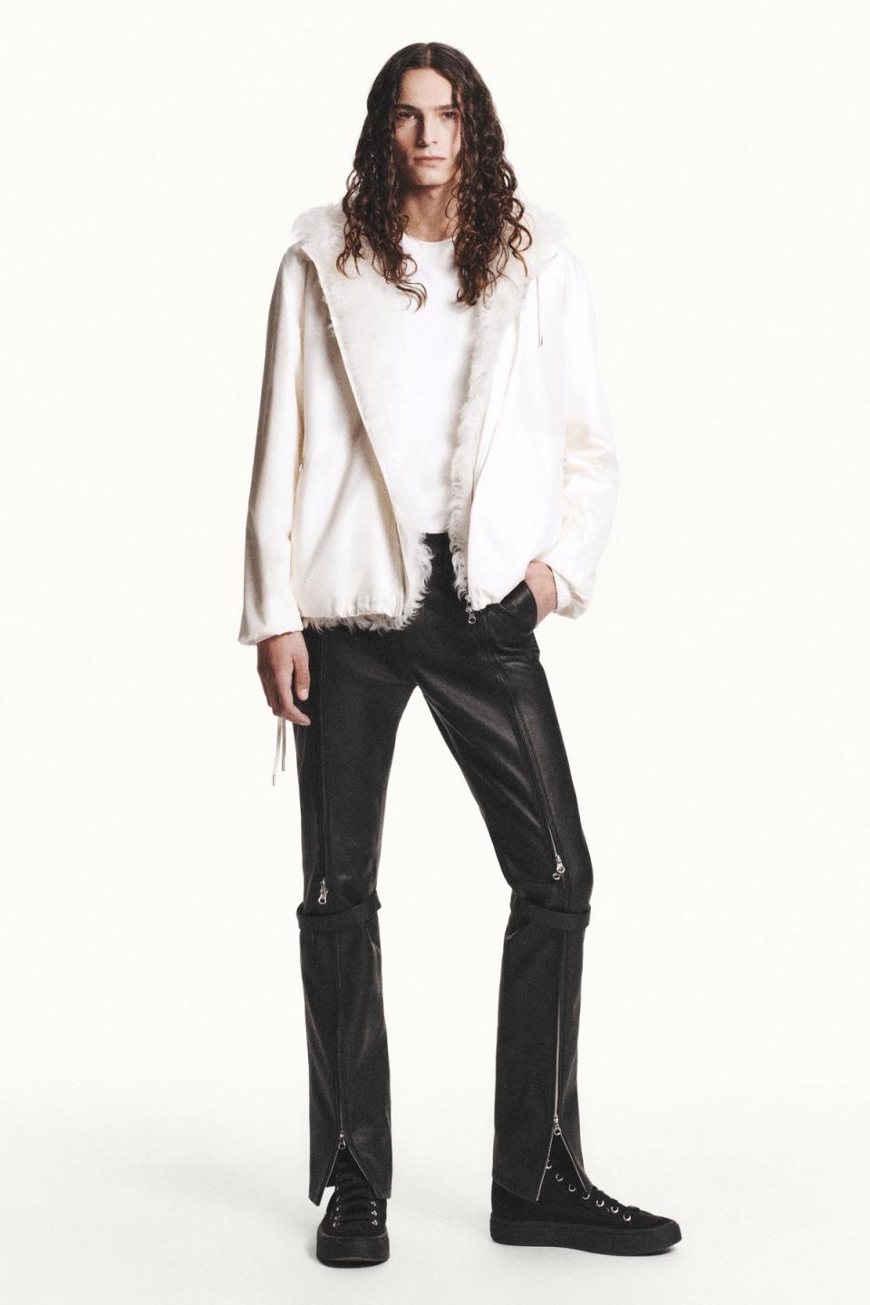 Elegant model wearing Courrèges white oversized jacket and black leather pants for a chic look.