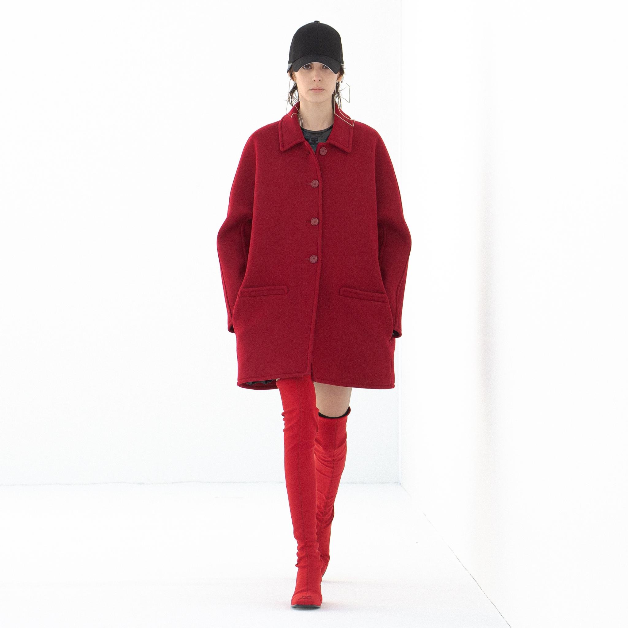 Manteau rouge élégant, ample, avec col classique et fermeture à boutons, style Courrèges.