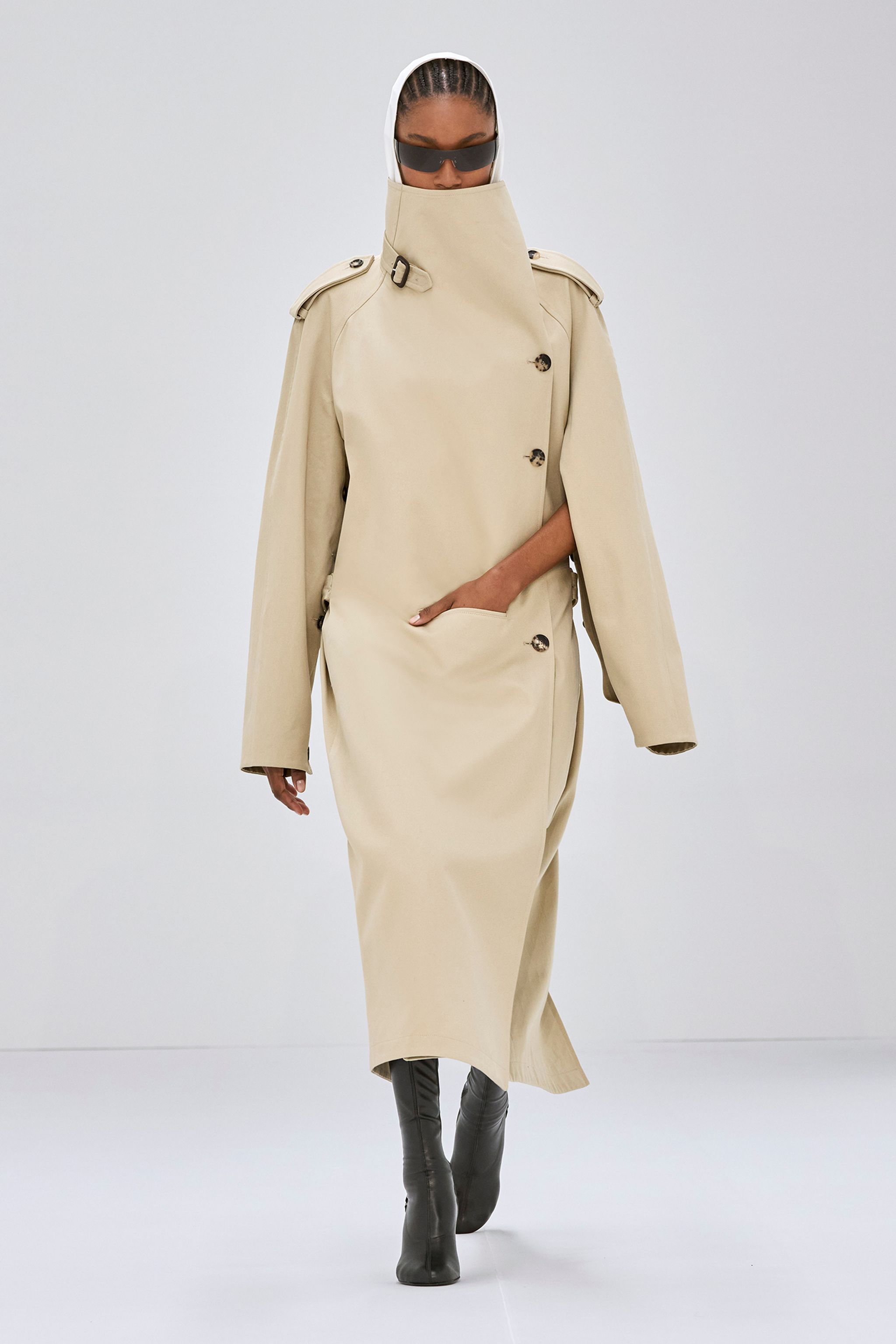 Elegant beige trench coat with high collar and shoulder epaulets, Courrèges fashion style.