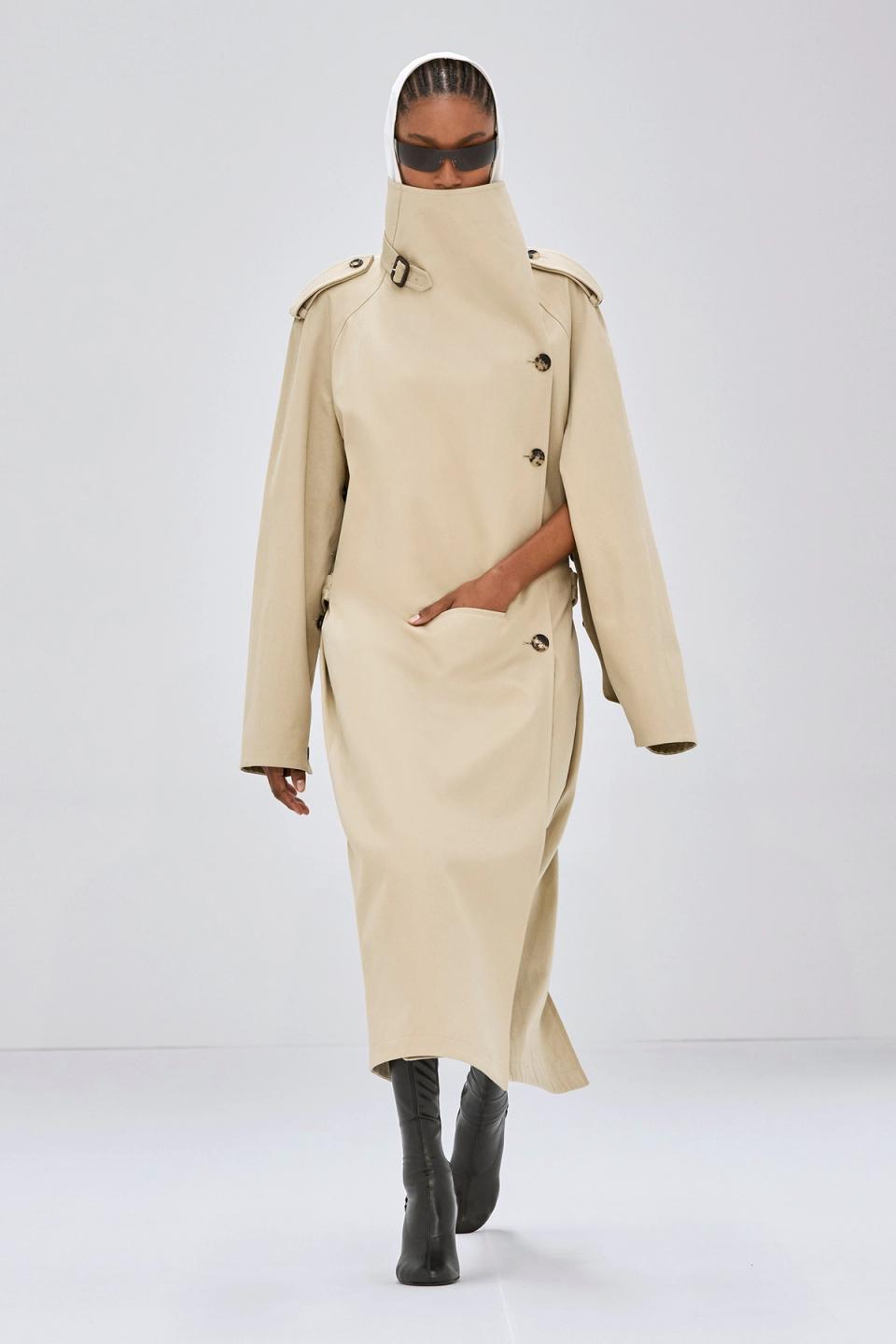Elegant beige trench coat with high collar and shoulder epaulets, Courrèges fashion style.