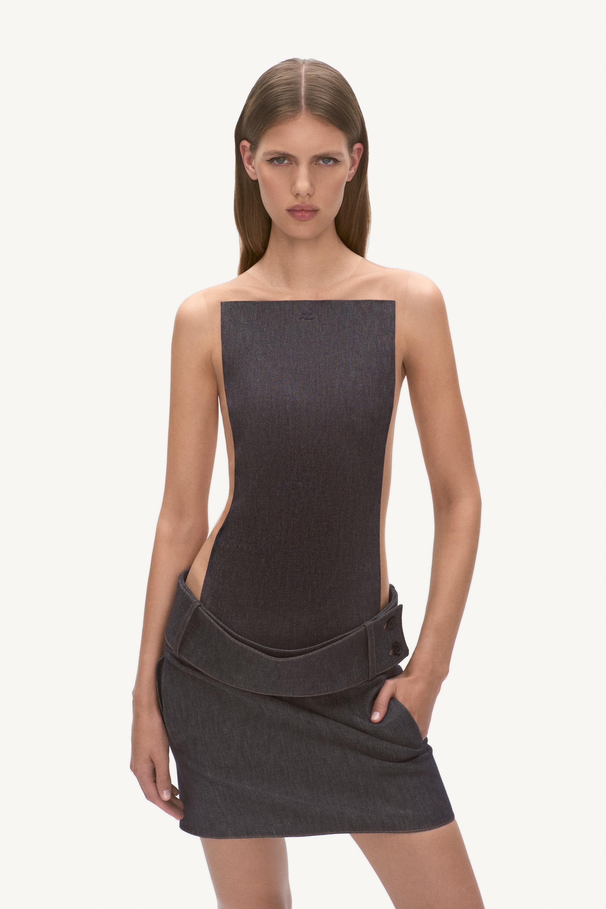 Elegant black top with cutouts, styled with a matching denim skirt from Courrèges, perfect for modern fashion.