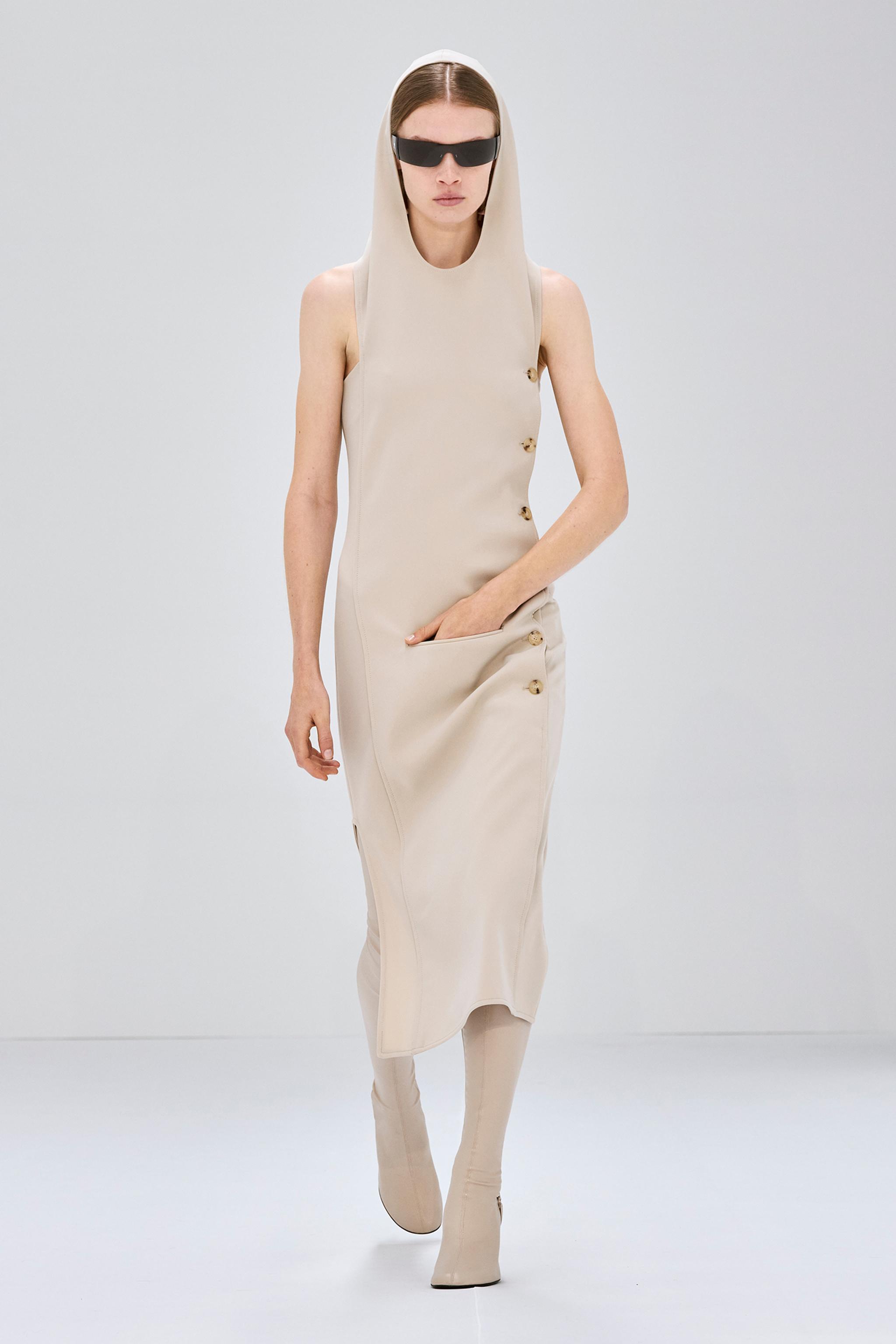 Robe beige élégante avec capuche, boutons tendance et bottes assorties pour la mode Courrèges.