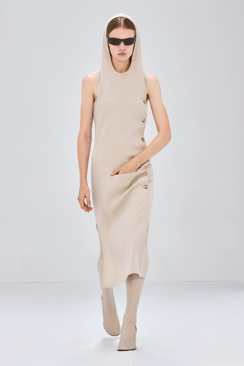 Elegant beige trench coat with asymmetric design, part of Courrèges fashion collection.