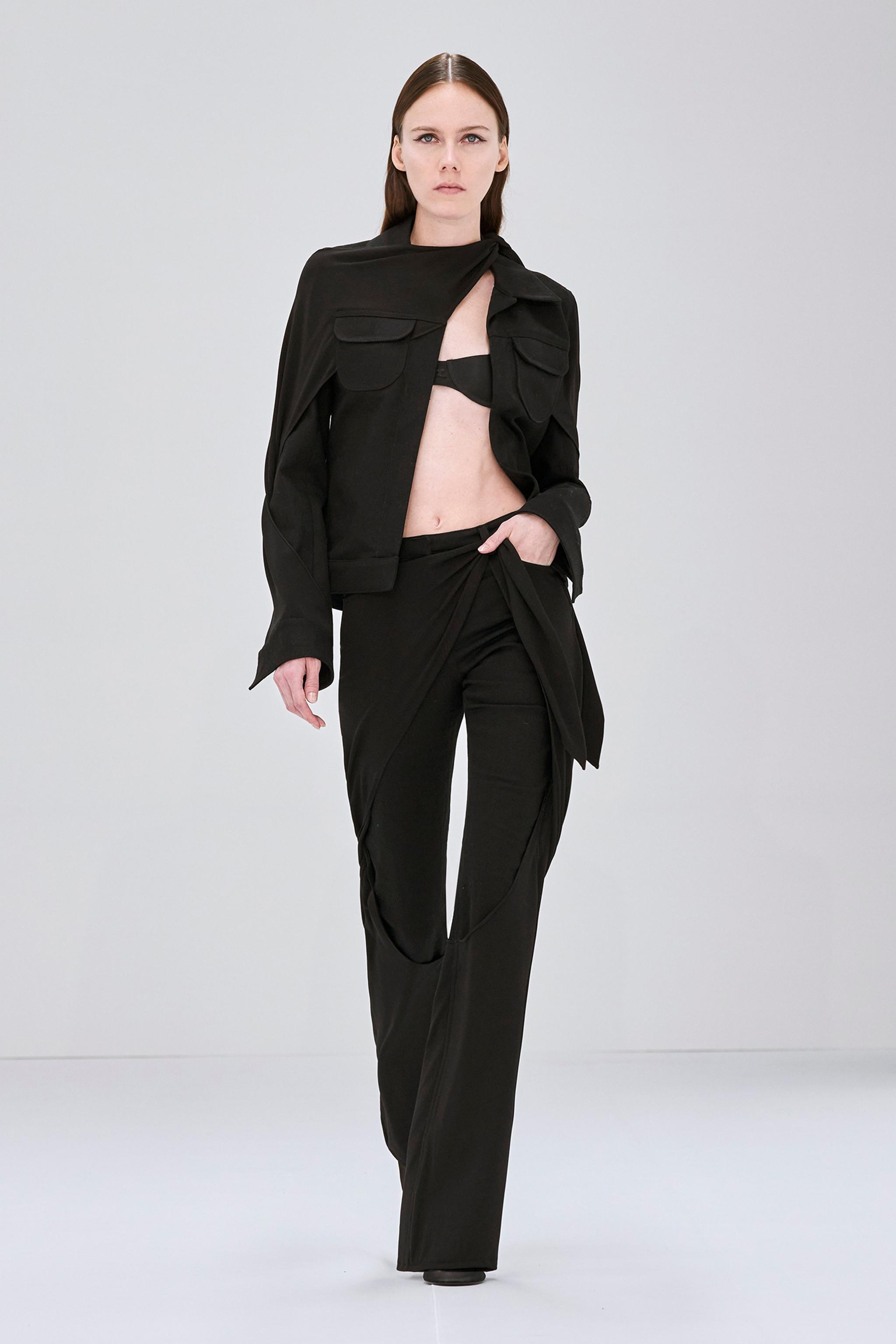 Ensemble mode noir élégant de Courrèges avec une veste courte chic et un pantalon à jambes larges.