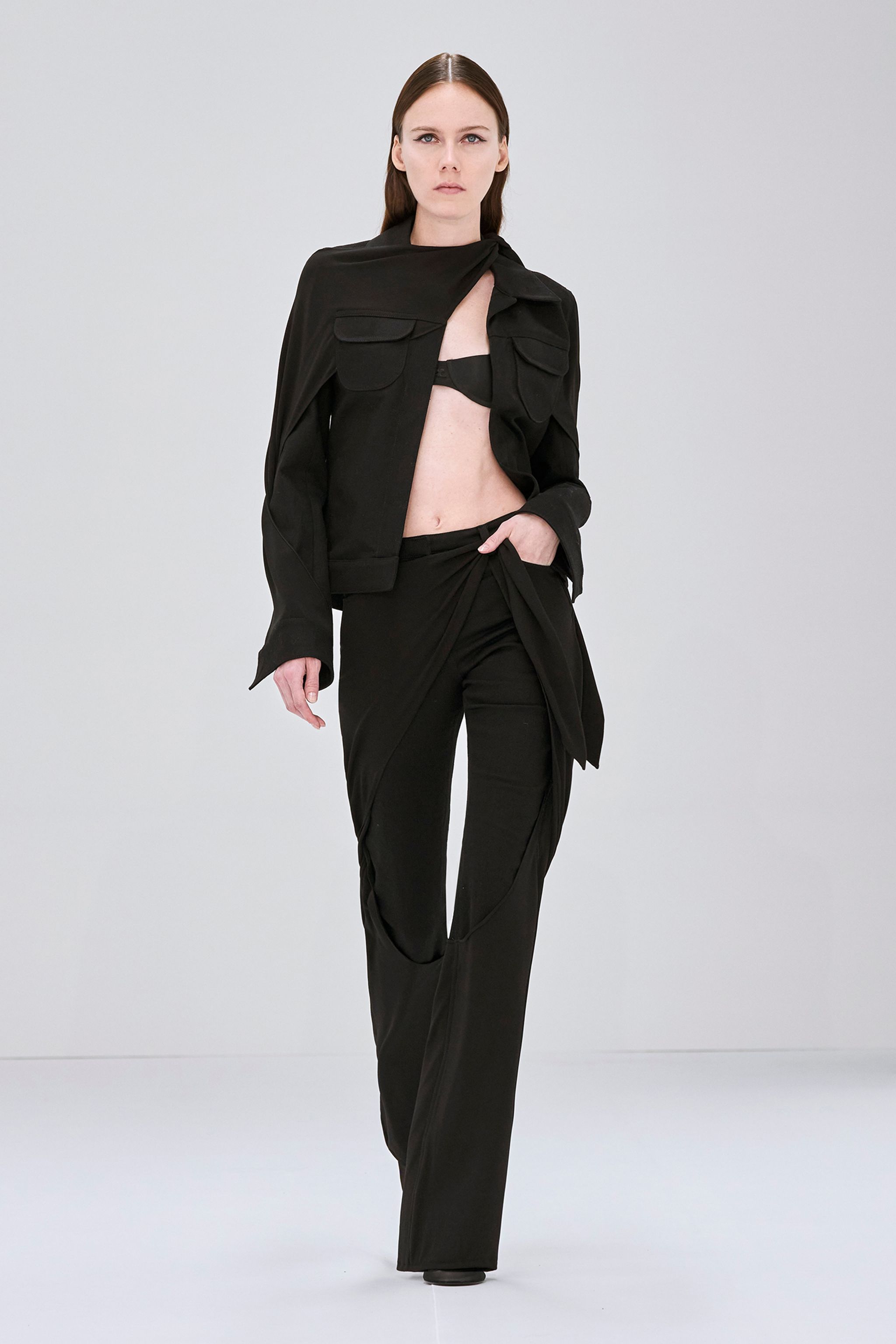 Elegant black fashion ensemble with a strapless top, long skirt, and futuristic sunglasses by Courrèges.