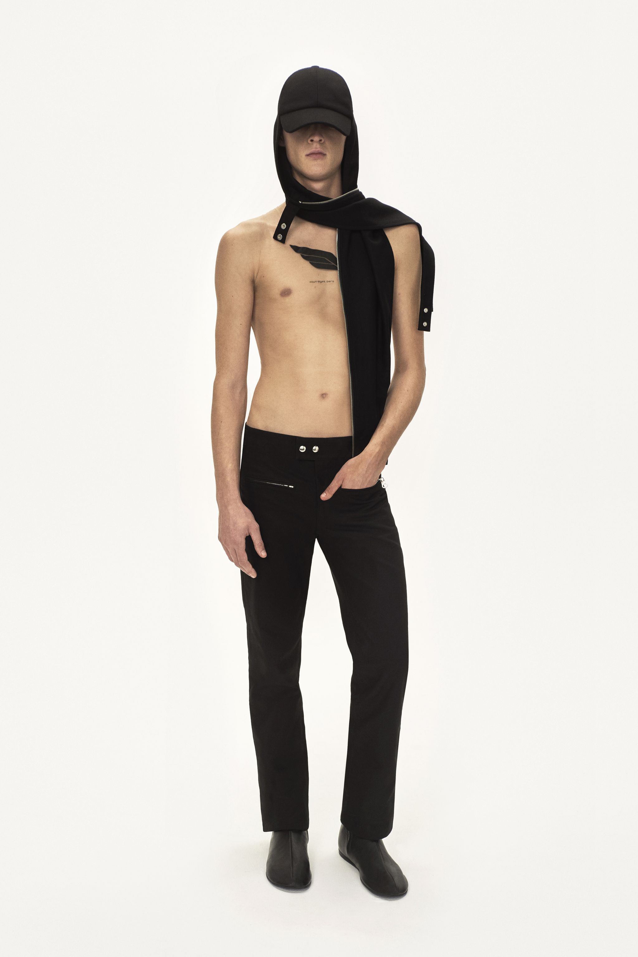 Fashion model showcasing Courrèges modern, edgy black streetwear on a minimalist background.