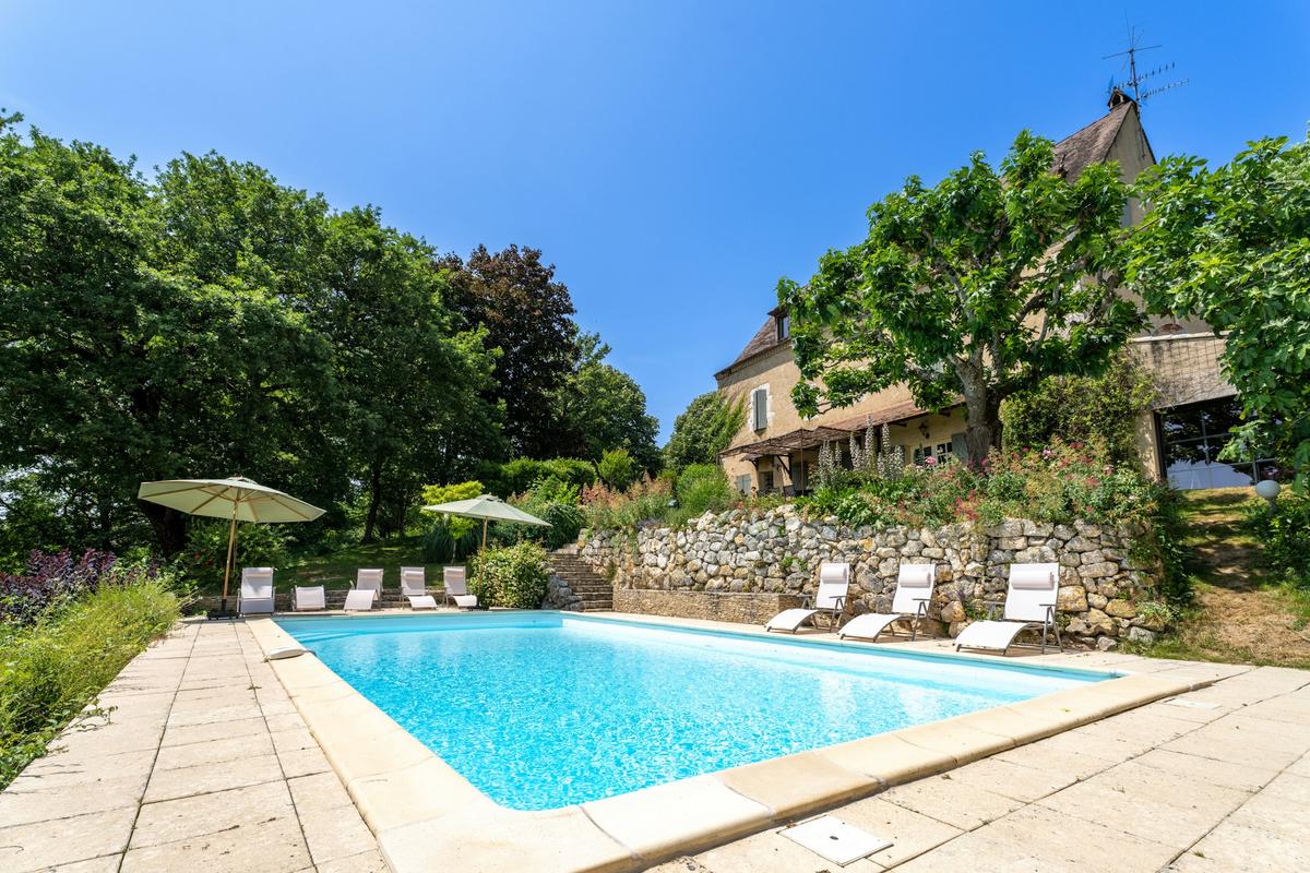 La piscine privée sous la maison de pierre, avec transats et parasols