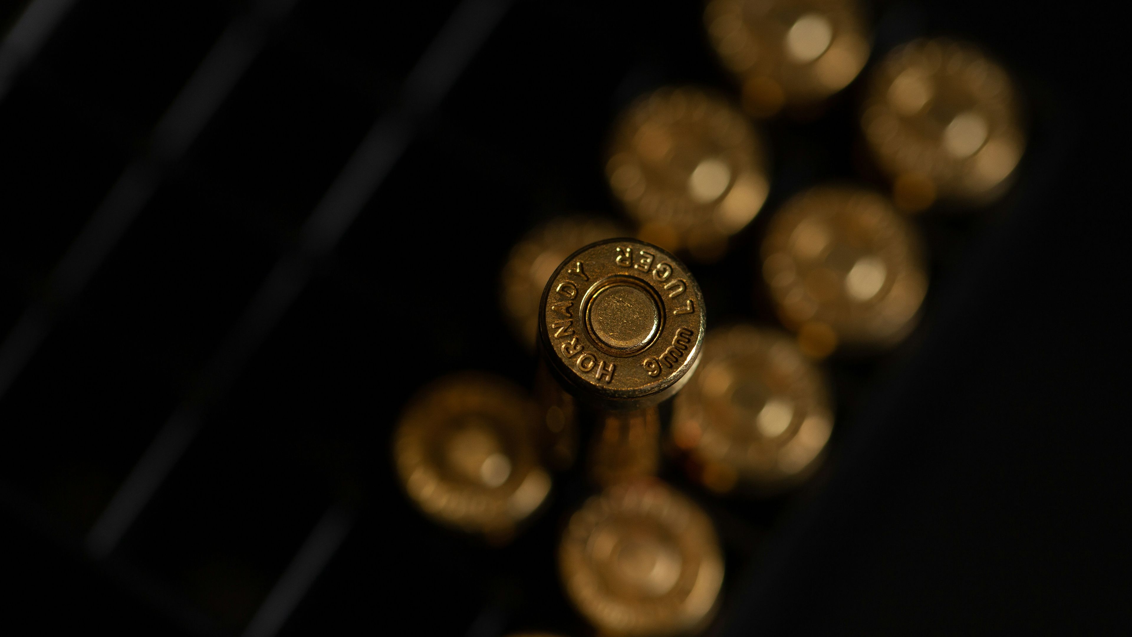 a close up of a bunch of gold bullets on a black surface .