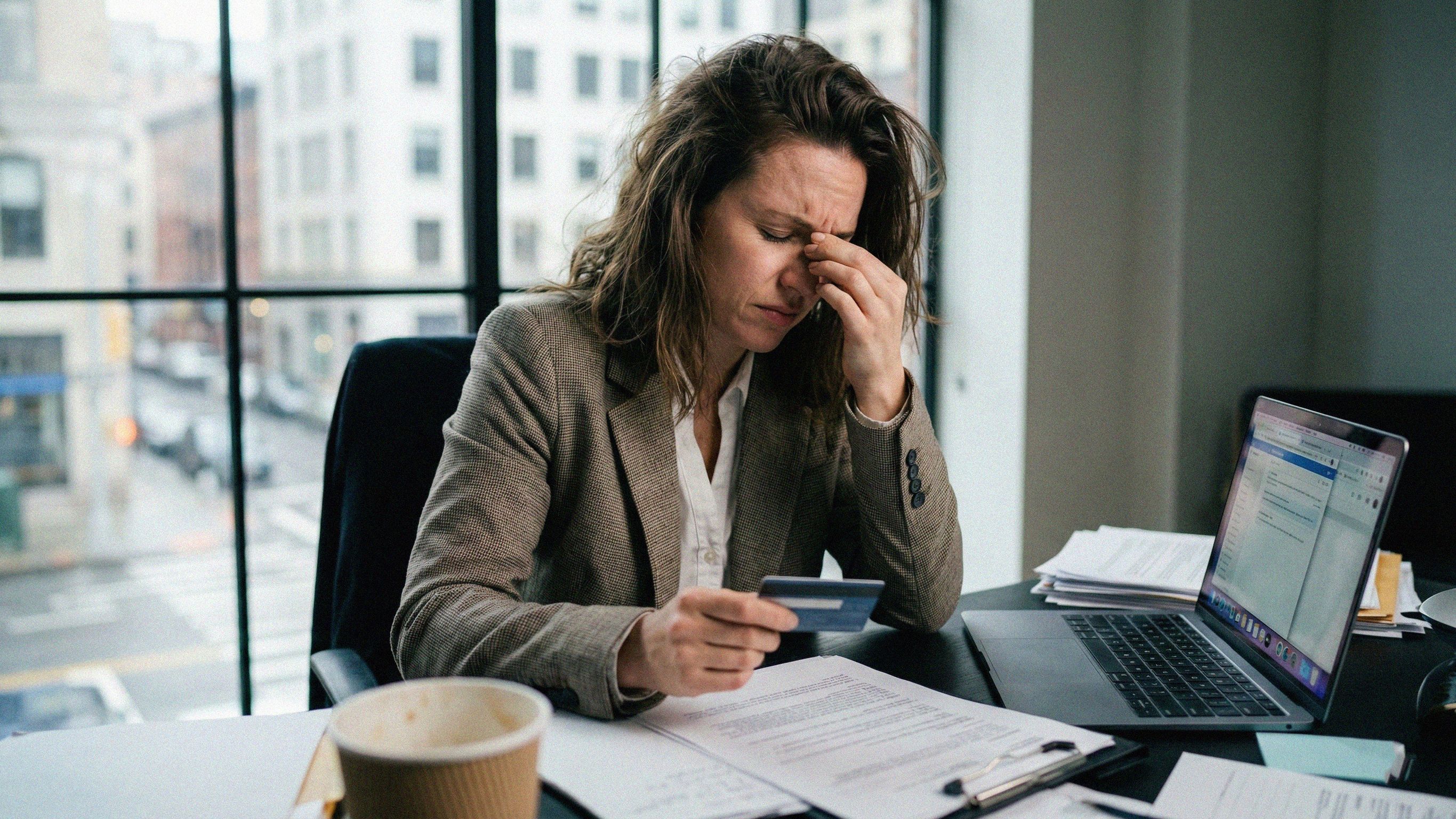 Businesswoman comparing merchant account providers on his laptop while going over financials
