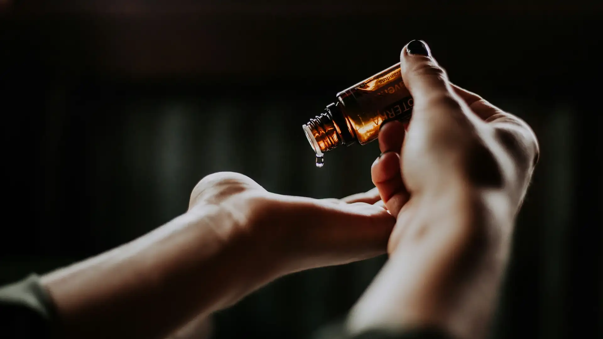 A woman is pouring essential CBD oil into her hand.