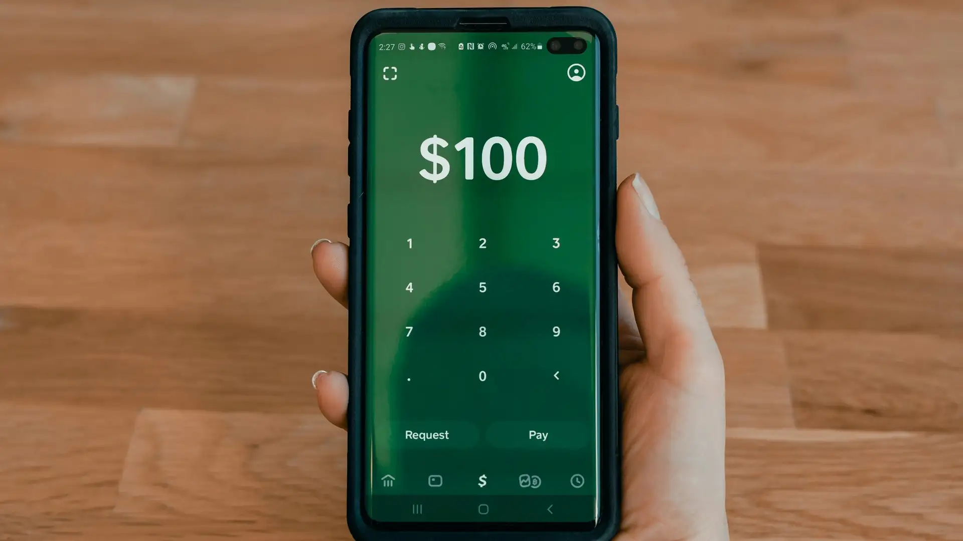 A person is holding a cell phone with a calculator on the screen.