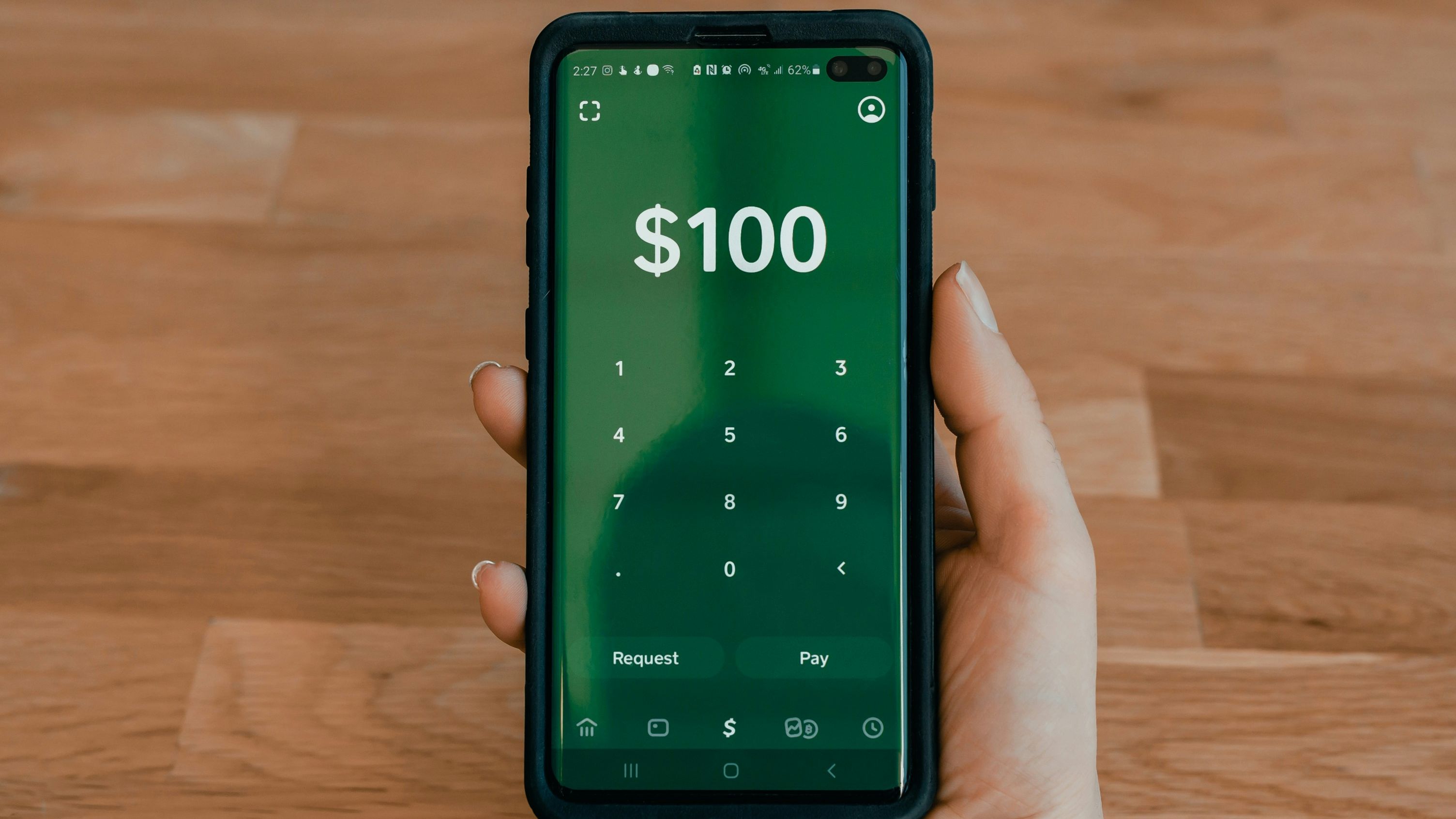 a person is holding a cell phone with a calculator on the screen .