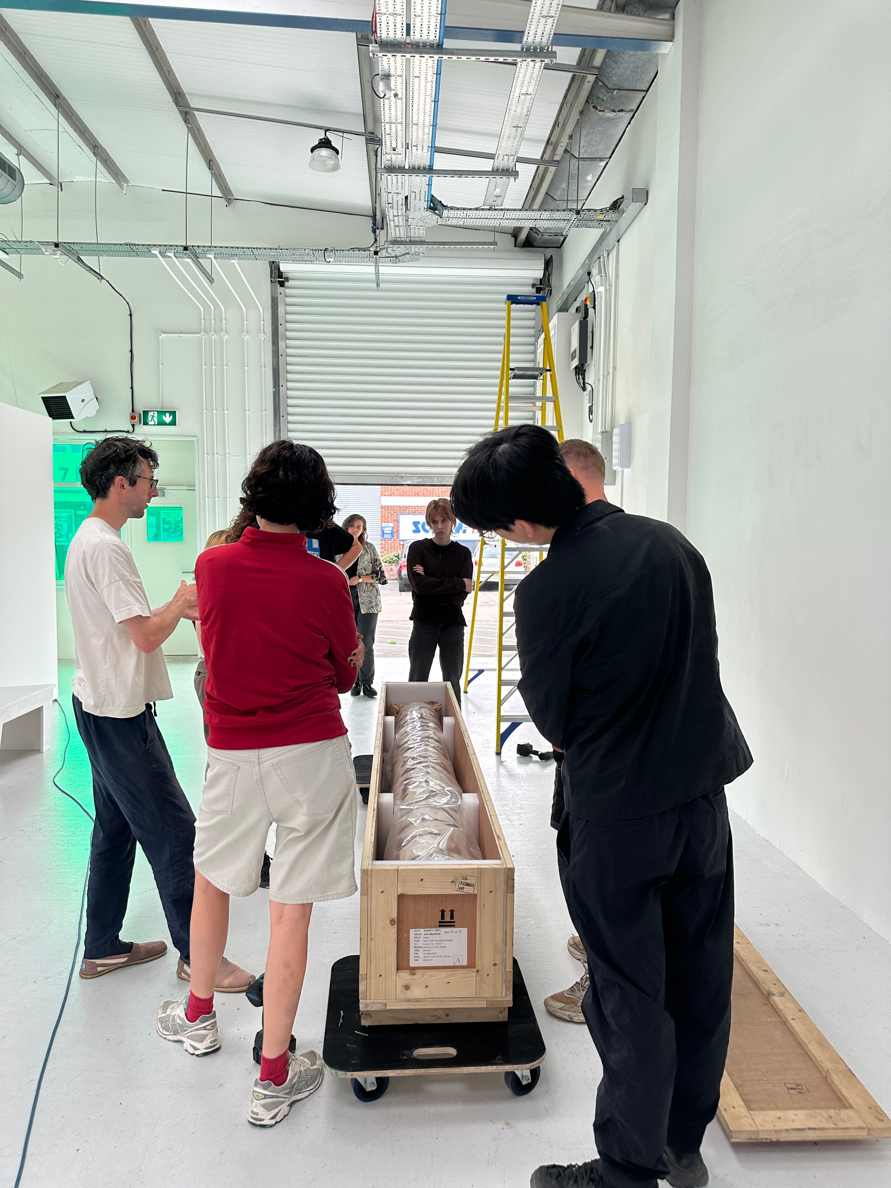 A group of people inspecting an artwork