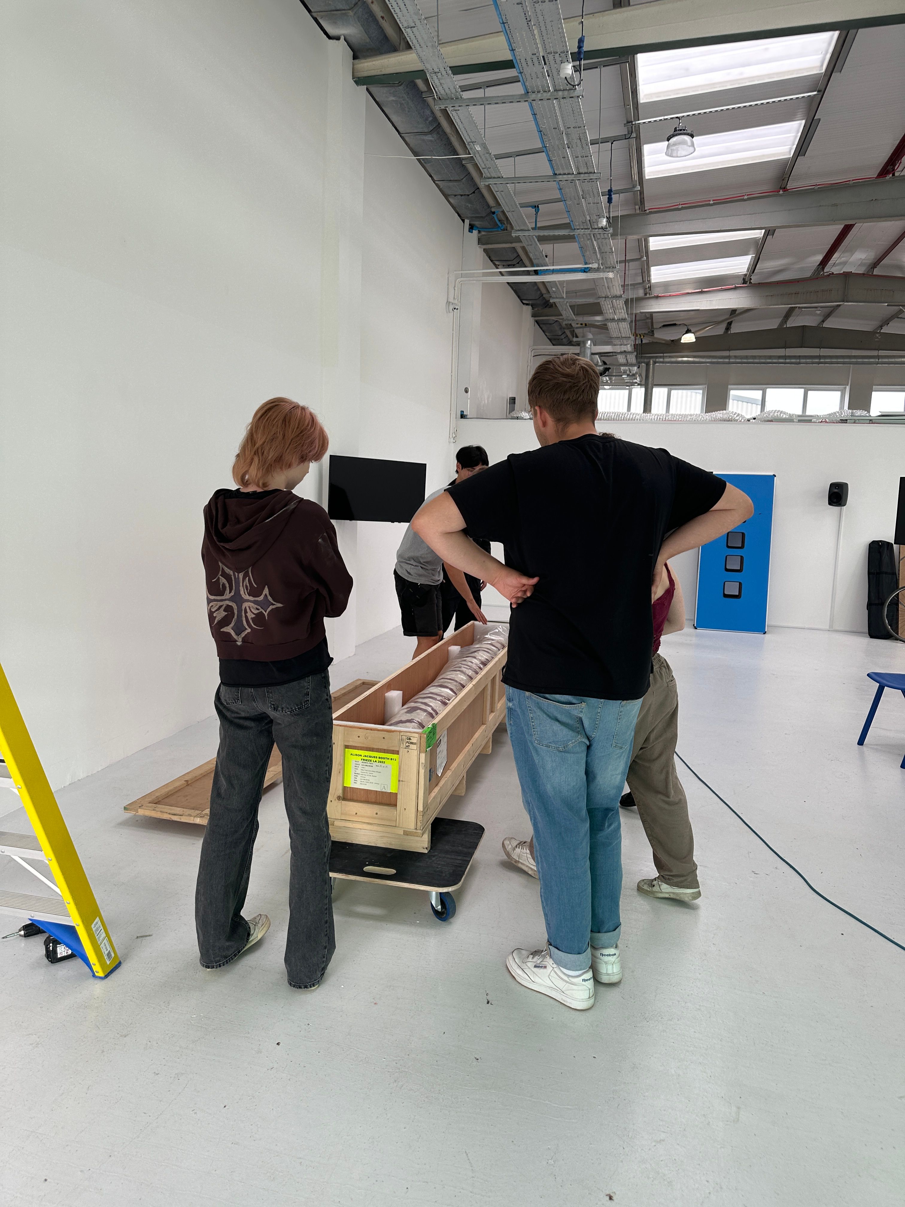 A group of people opening a crated artwork